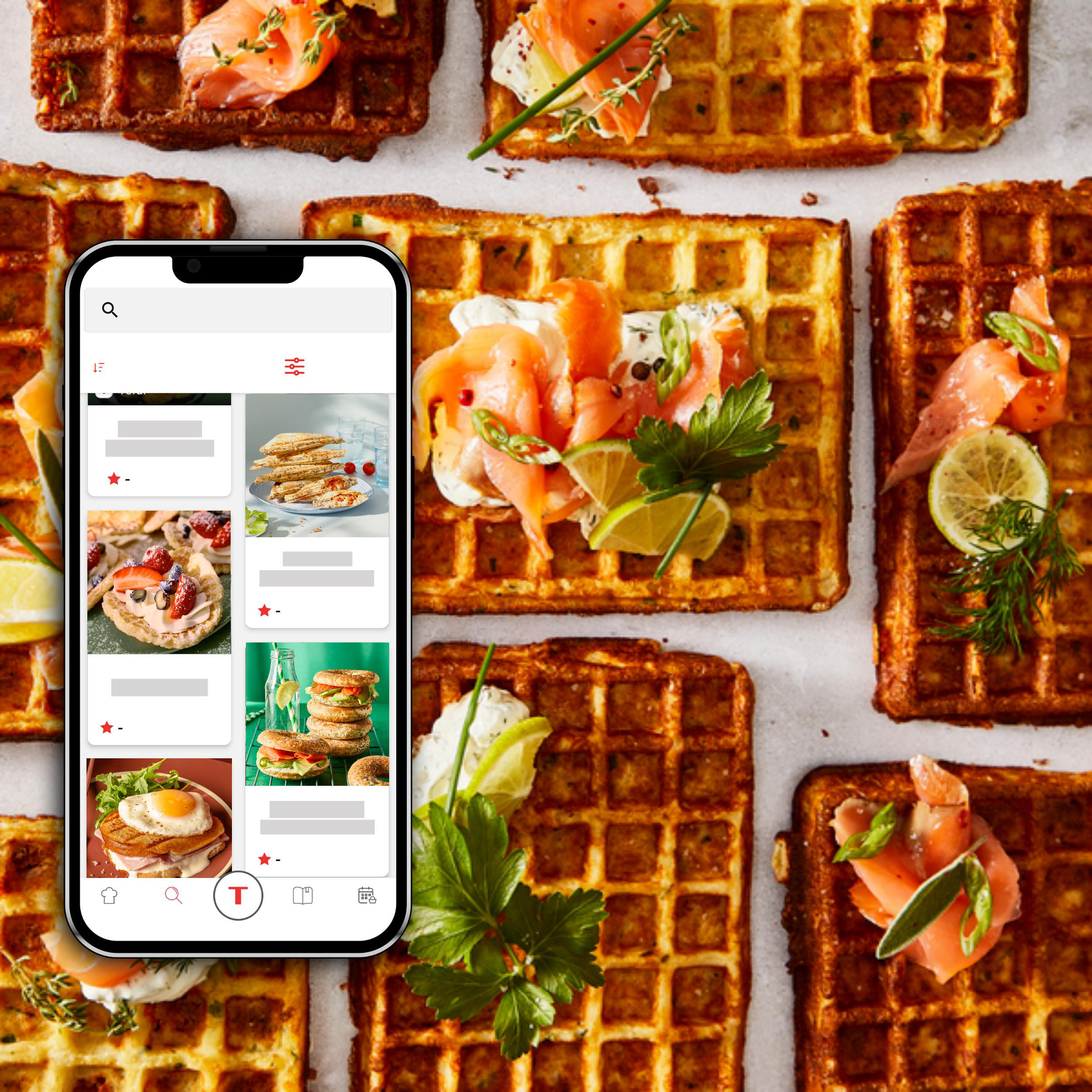 Ein Smartphone mit Waffelrezepten, umgeben von verschiedenen Waffeln und Belägen.