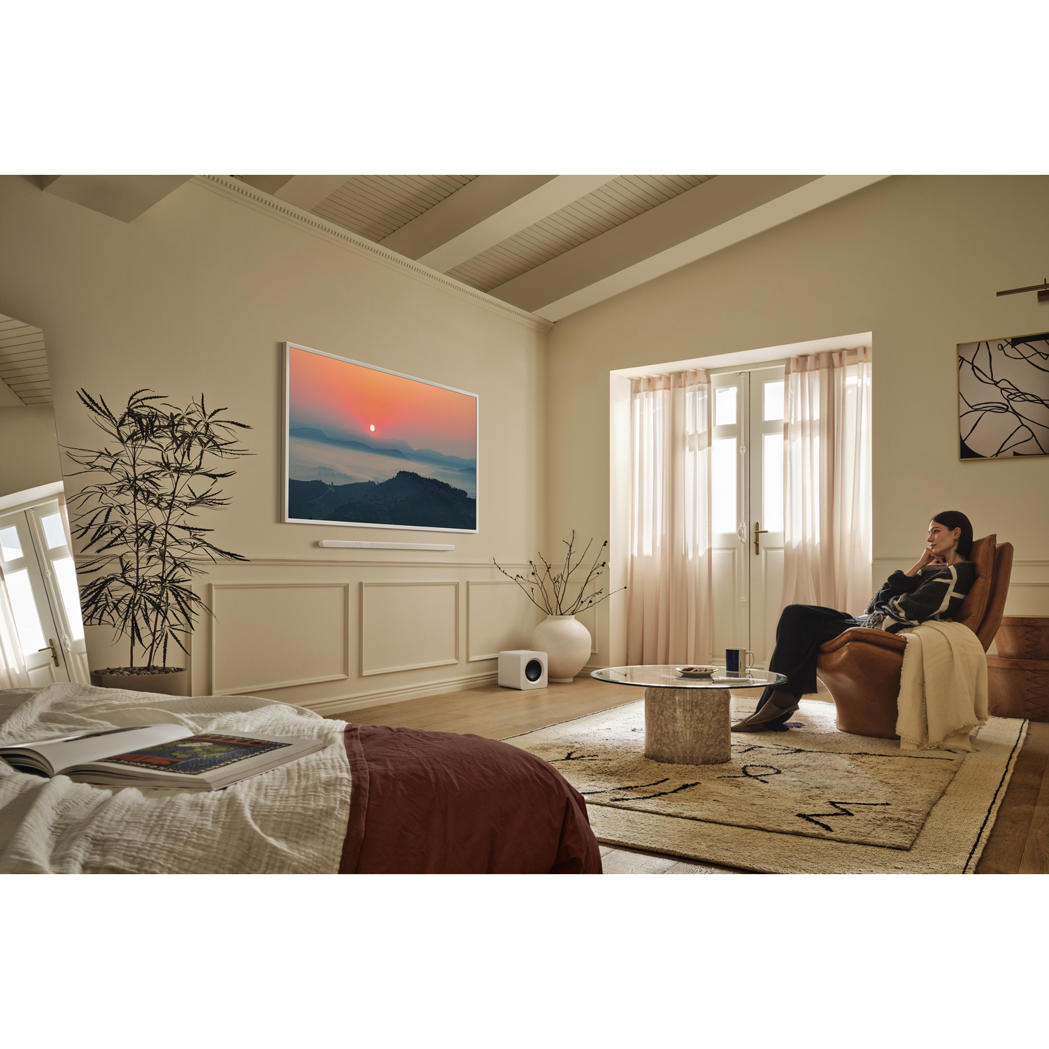 Woman watching sunset on TV in a cozy room. There is a sofa, a coffee table, and a mirror.