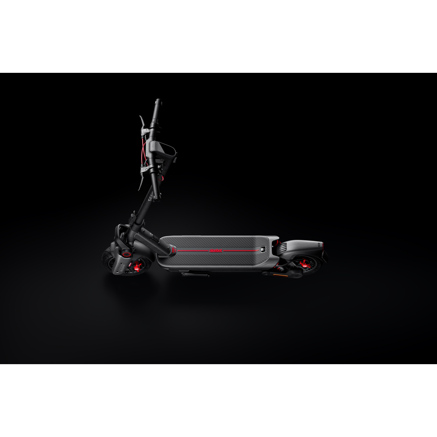 Scooter elettrico nero e rosso su sfondo nero.