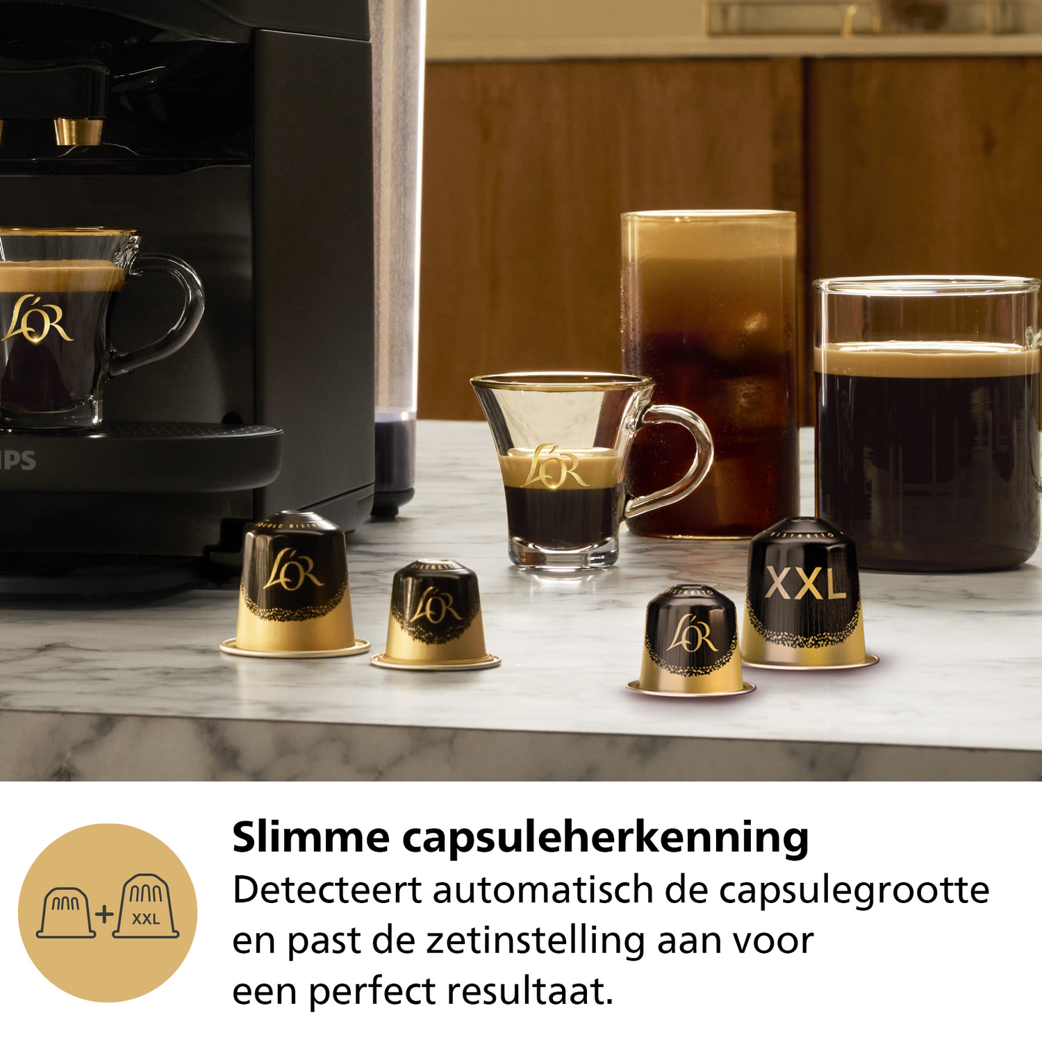 Coffee machine with cups and coffee capsules on a marble surface.