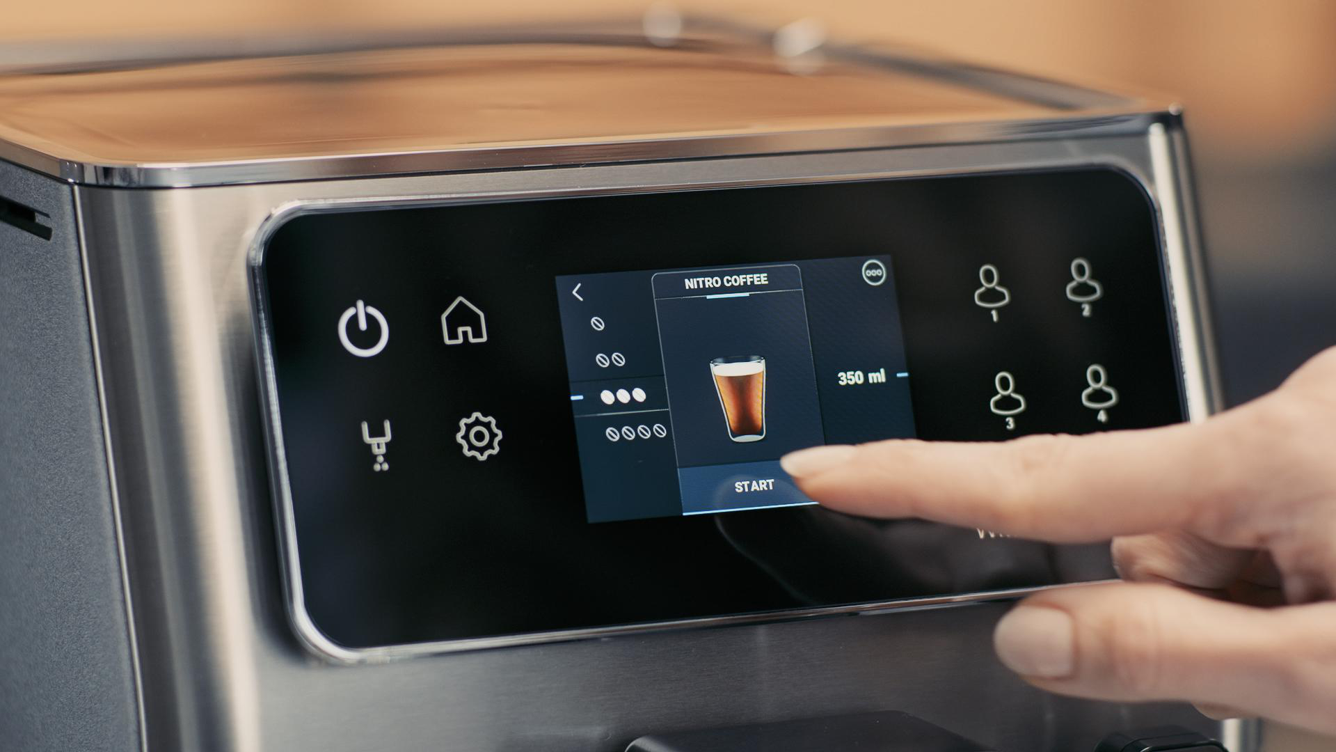 Kaffeemaschinenbildschirm zeigt Nitro-Kaffee-Option. Ein Finger berührt die Starttaste.