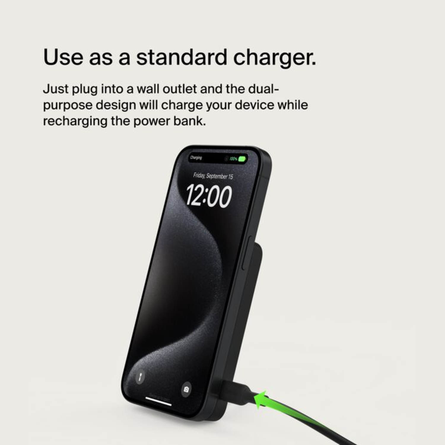 Téléphone noir en charge, branché sur une prise murale. L'écran affiche l'heure et la batterie.