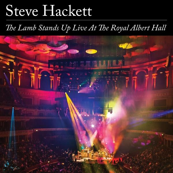Konzertsaal mit Bühne und Publikum. Bühne hat Lichter und Band. Text: Steve Hackett, The Lamb Stands Up.
