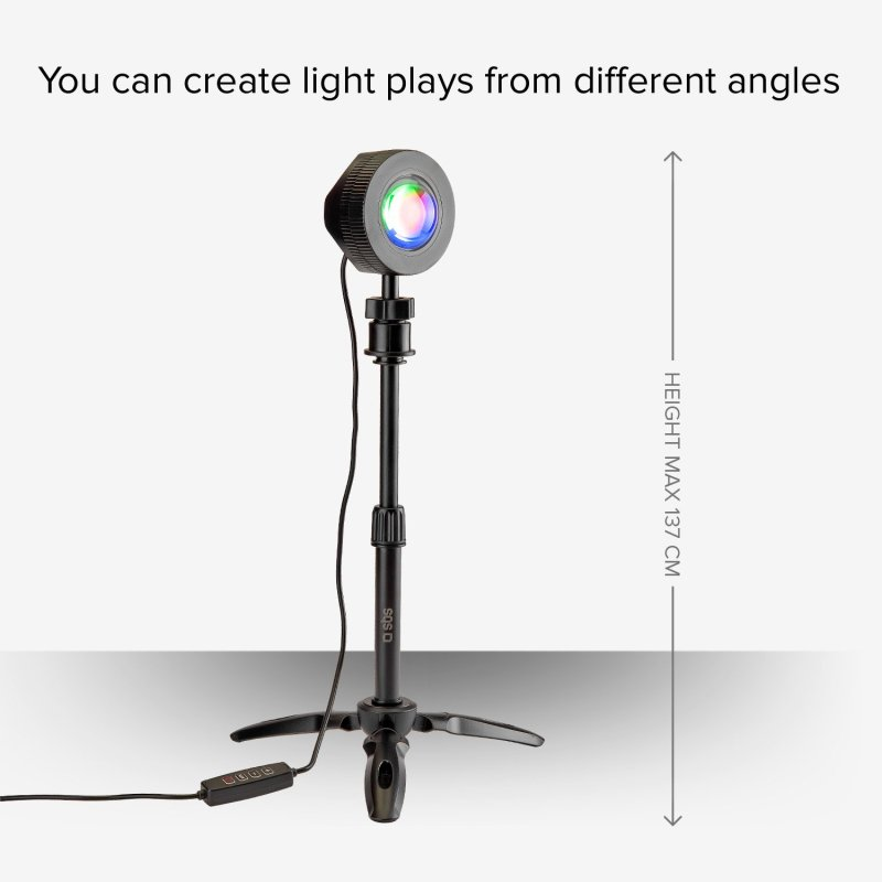 Projektor światła na statywie, światło tęczowe. Szara ściana z tekstem.