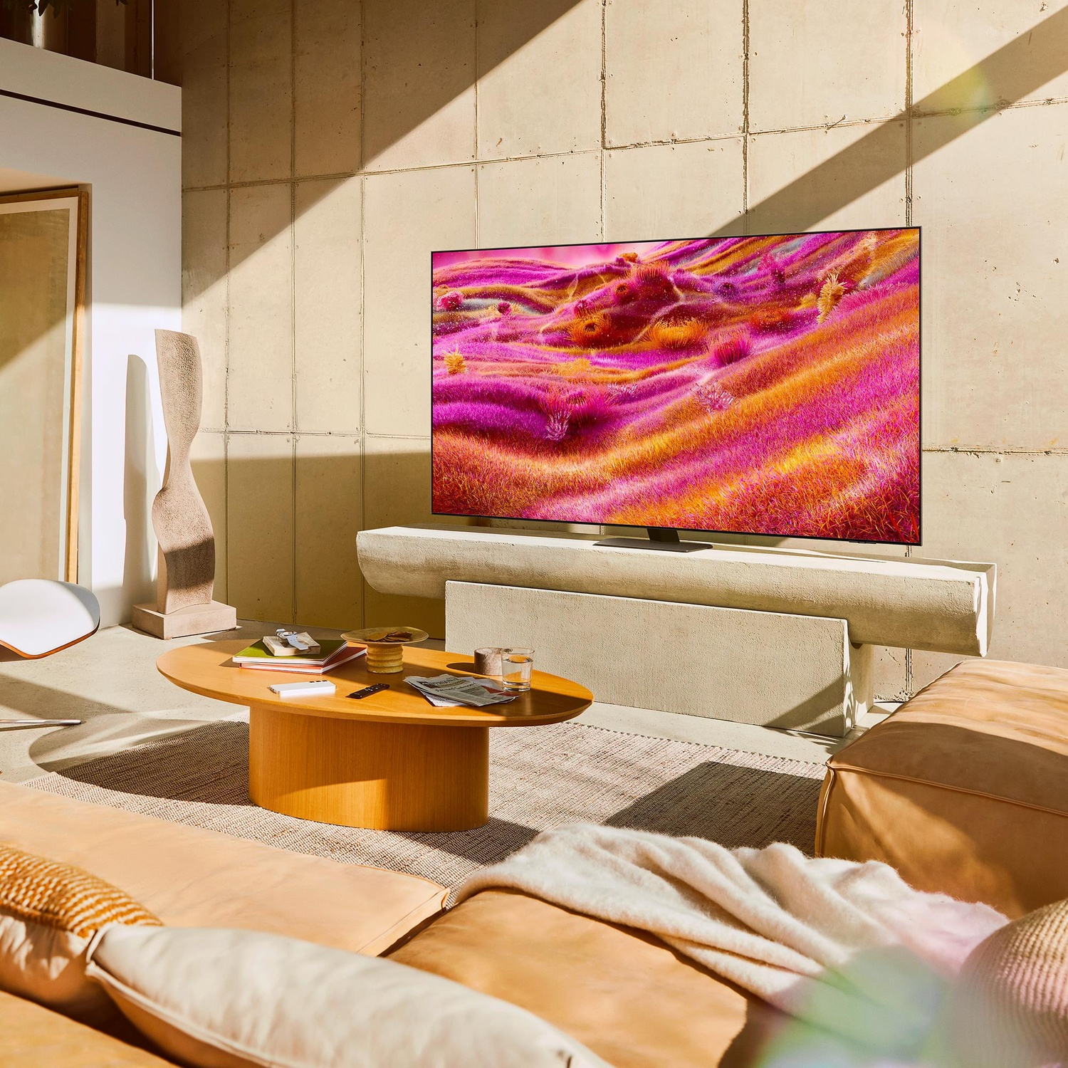 Un soggiorno con una TV che mostra un paesaggio colorato. L'arredamento include divano, tavolo e decorazioni.