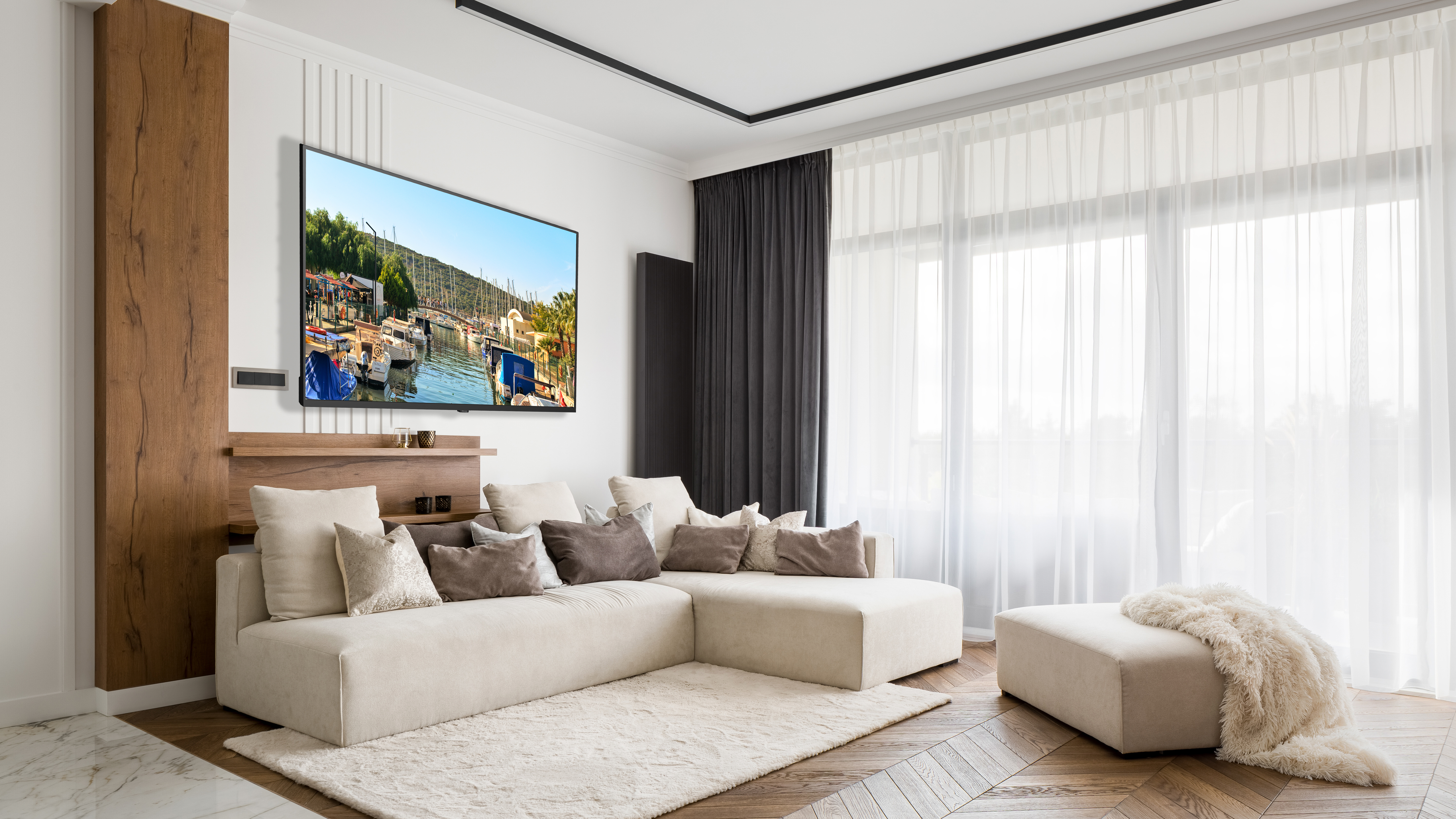 Duvarda büyük bir TV, kanepe ve halı bulunan oturma odası.