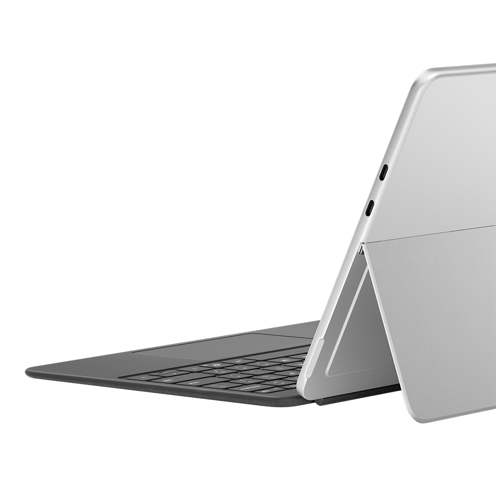 Ein Laptop mit geöffnetem Deckel, schräg auf schwarzer Oberfläche. Die Tastatur ist sichtbar.