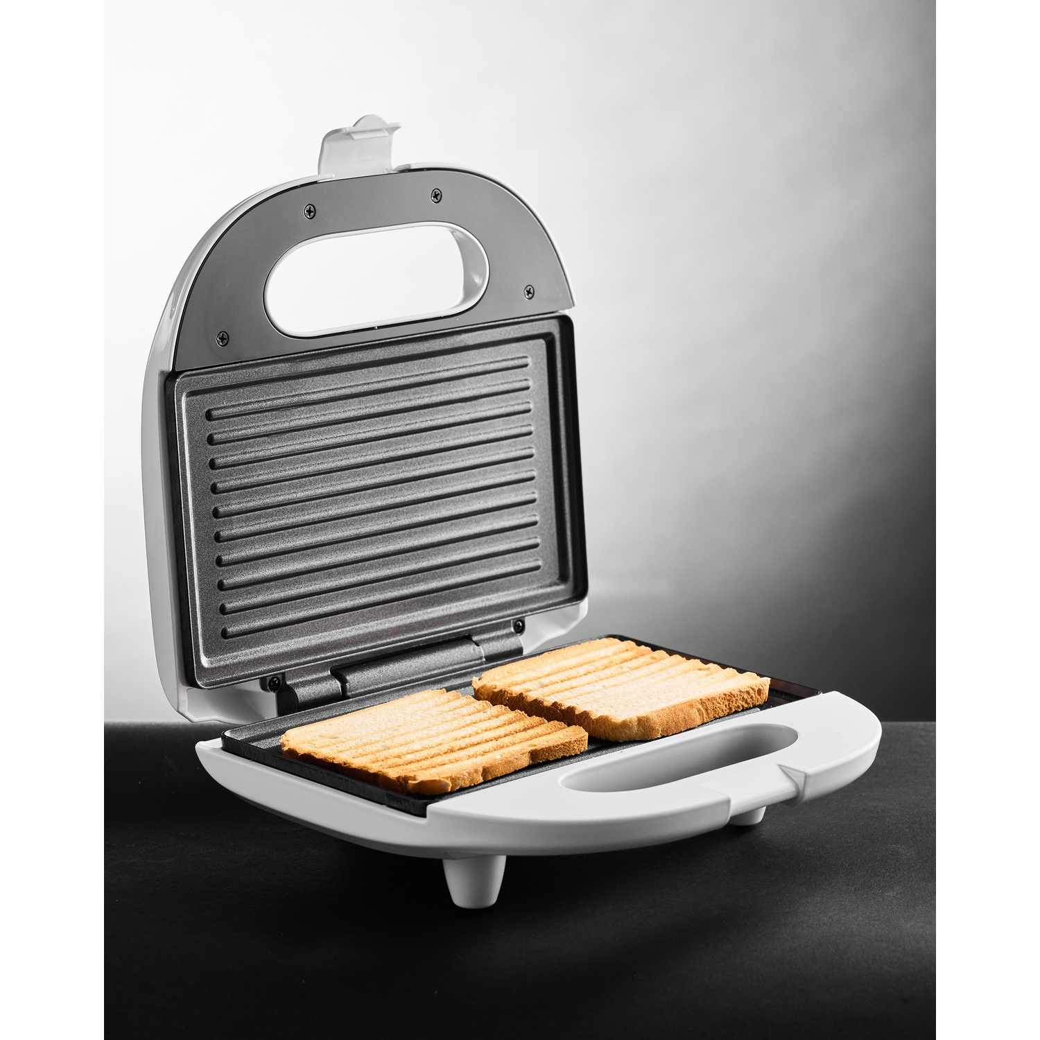 Tostapane bianco con due fette di pane tostato all'interno.