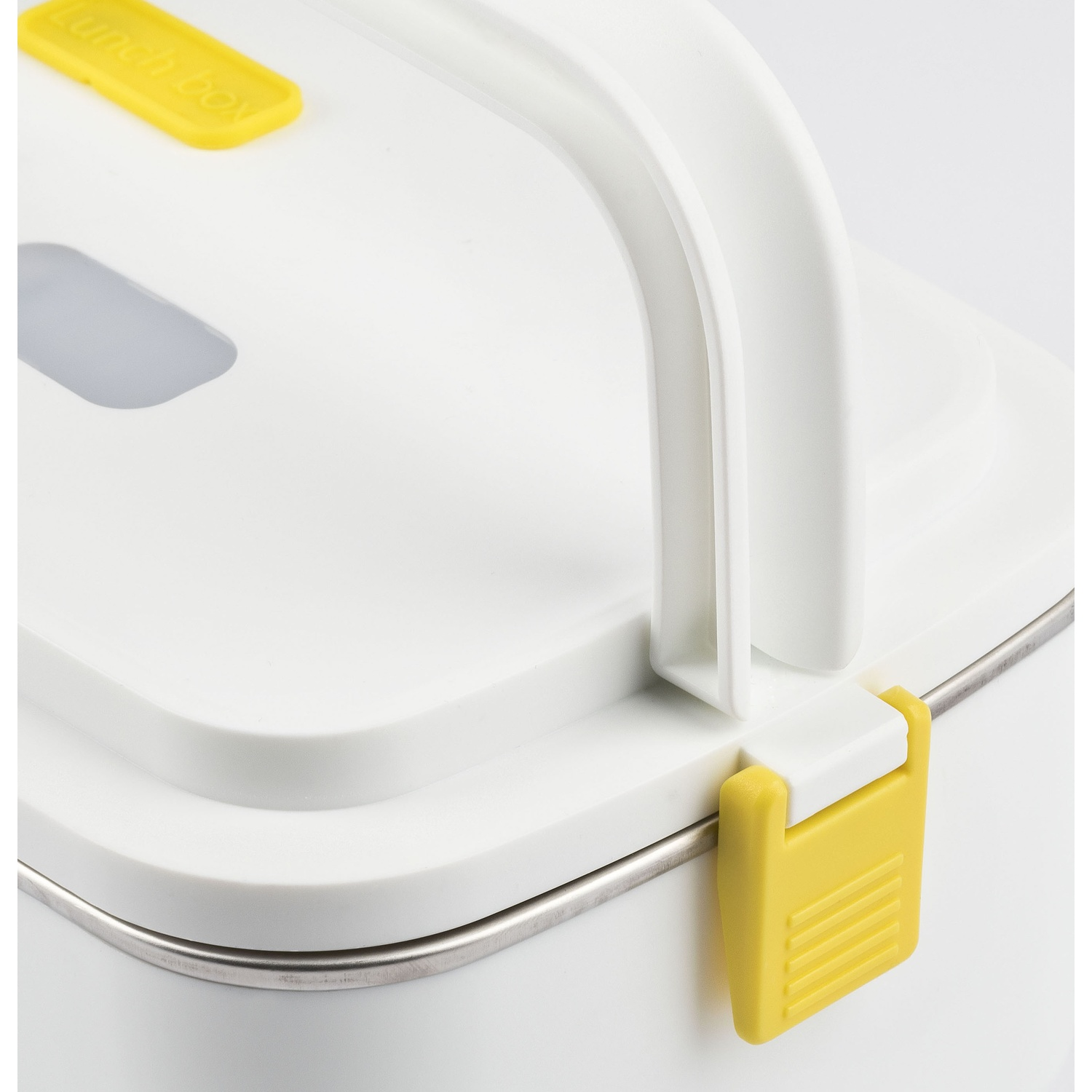Primo piano di un lunch box bianco con chiusura gialla.