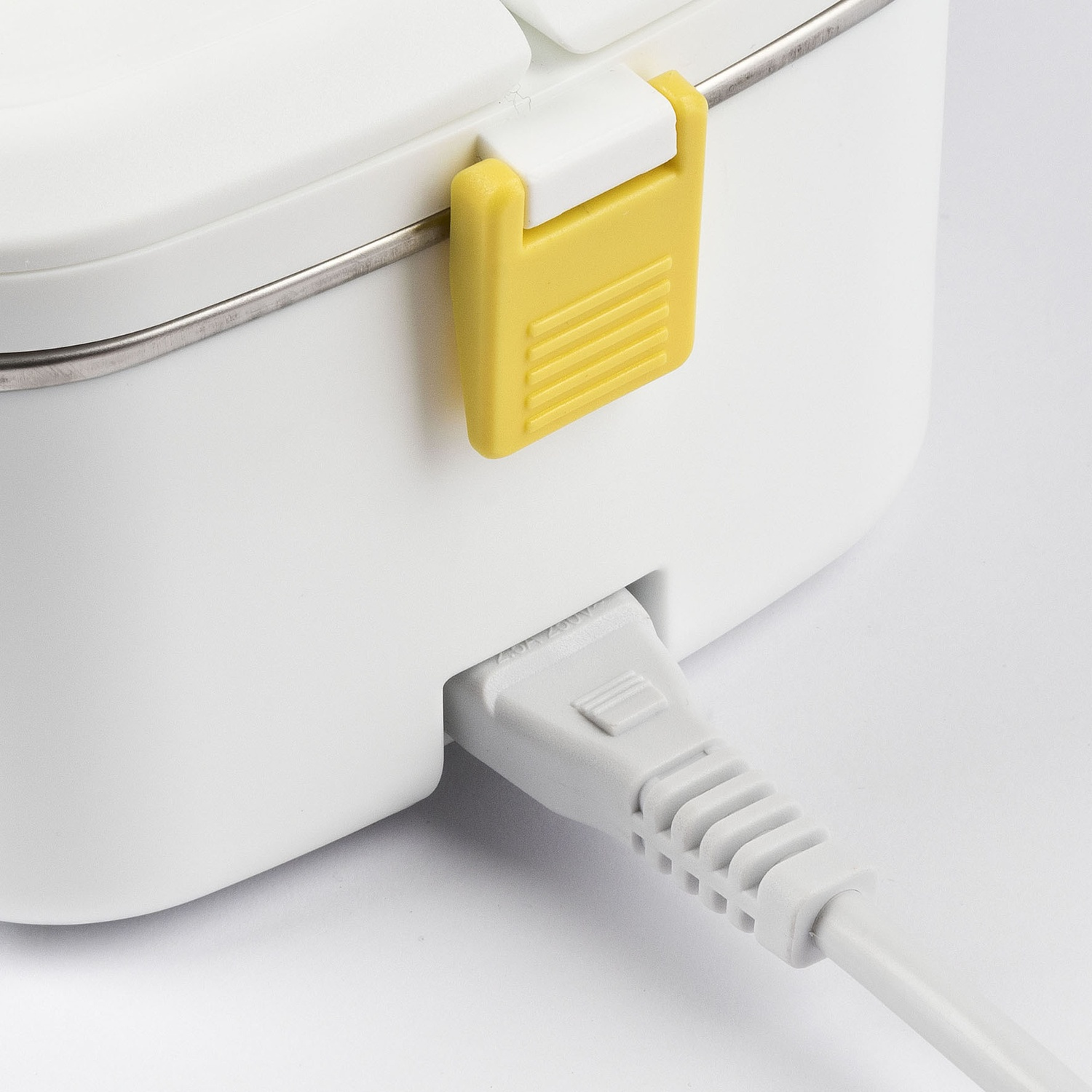 Primo piano di un lunch box bianco con cavo di alimentazione grigio.