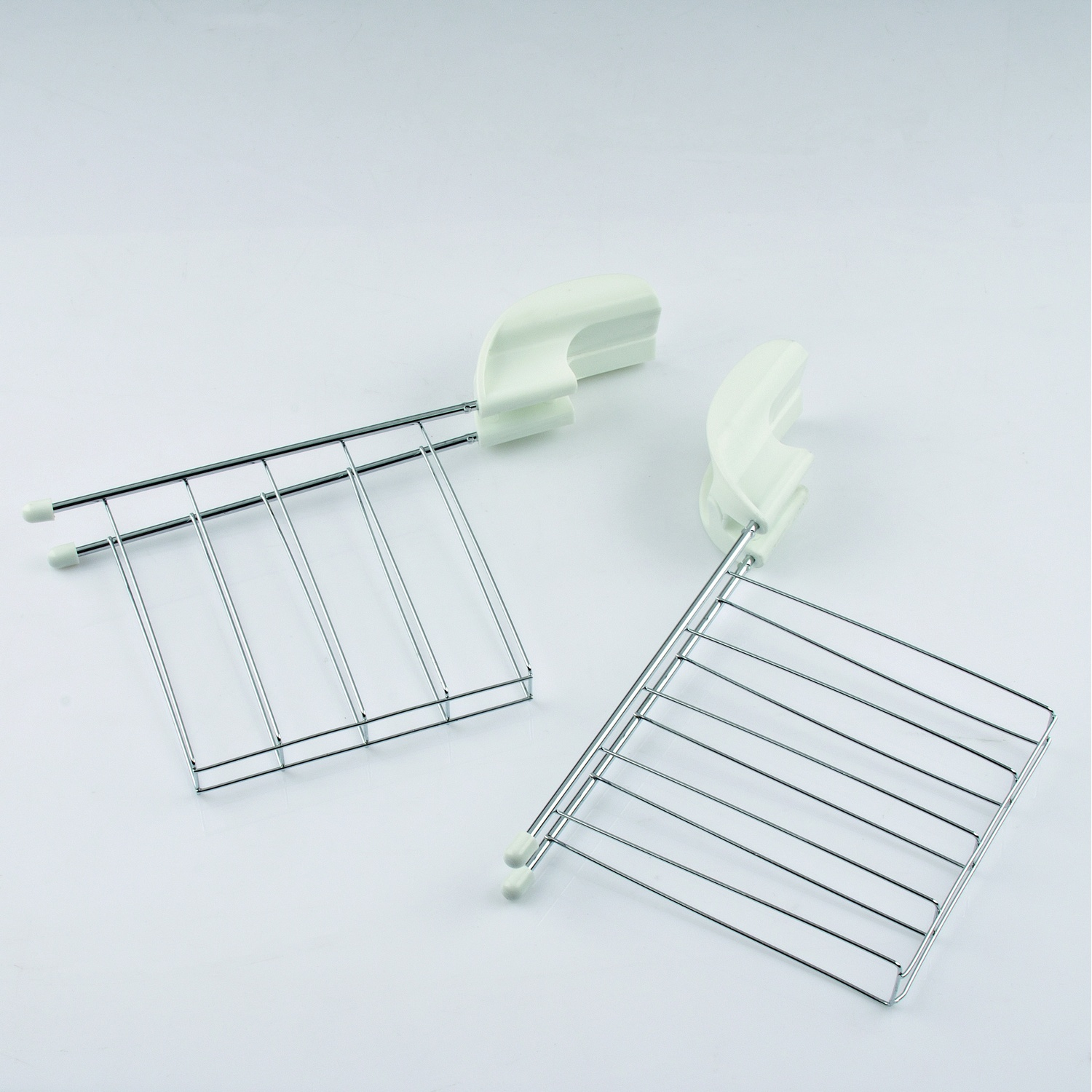 Due griglie per tostapane bianche con manici in plastica bianca su sfondo bianco.