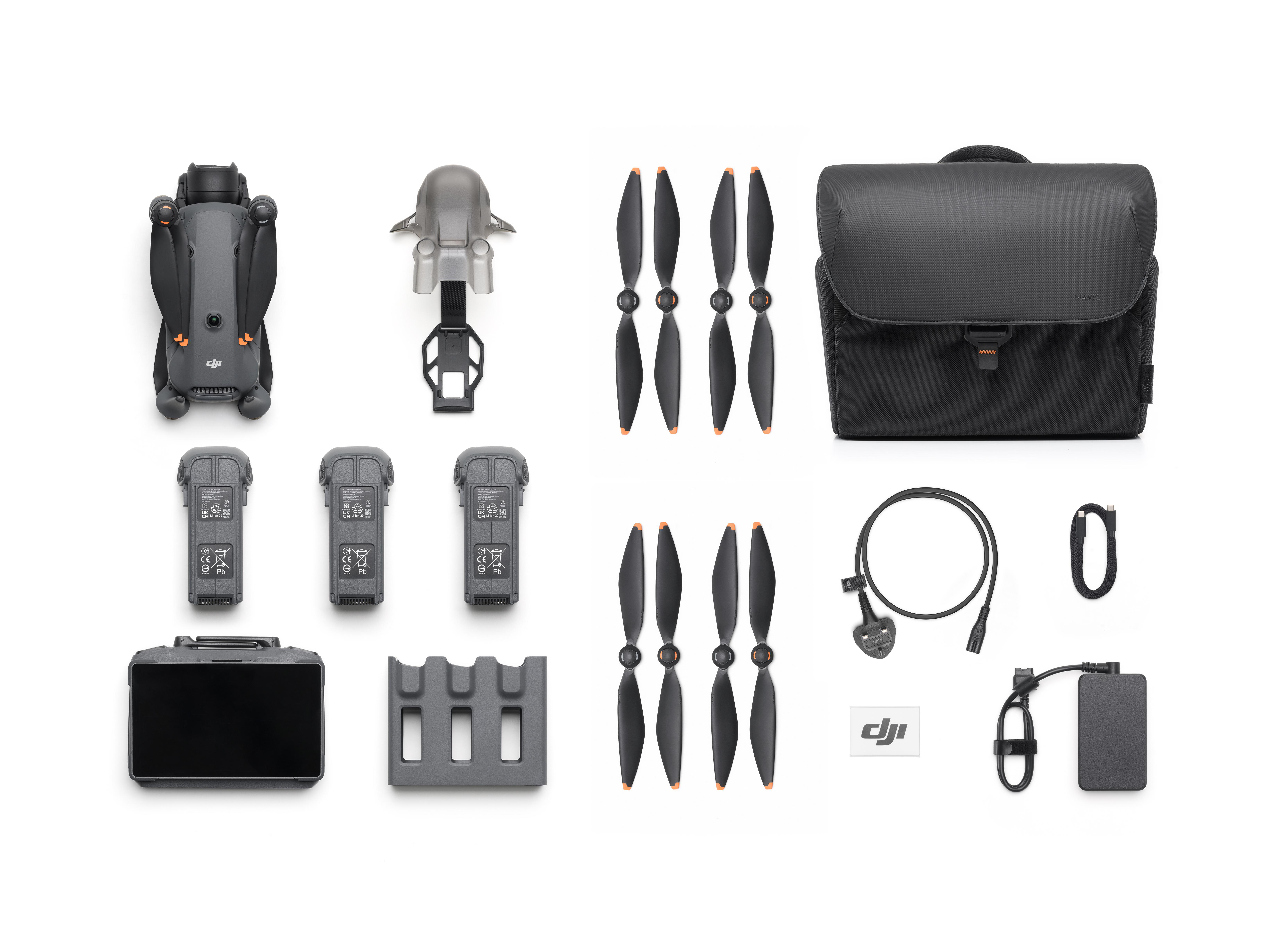 Drohnenzubehör: Propeller, Akkus, Tasche, Ladegerät und Controller auf Weiß.