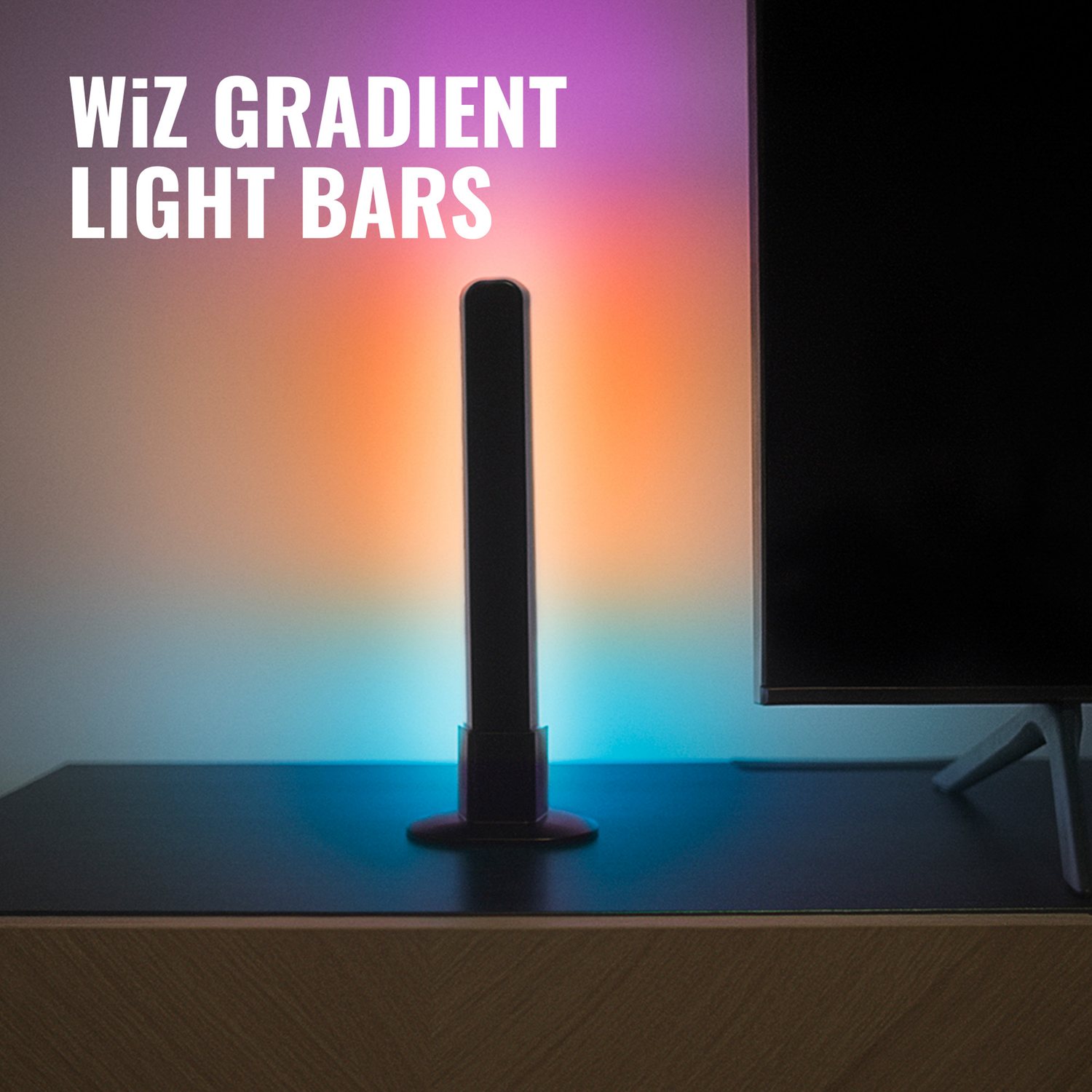 A gradient light bar next to a TV on a black surface and a colorful wall.
