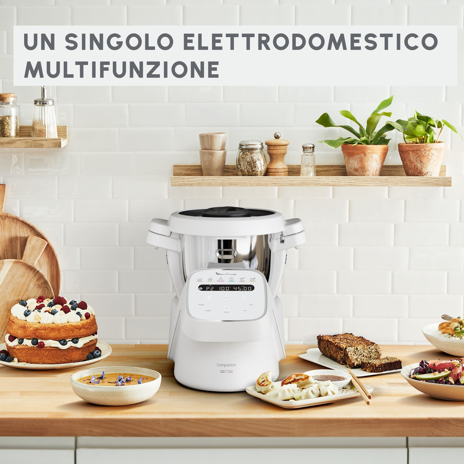 Un elettrodomestico da cucina bianco con display digitale. Ci sono una torta e altro cibo sul bancone.