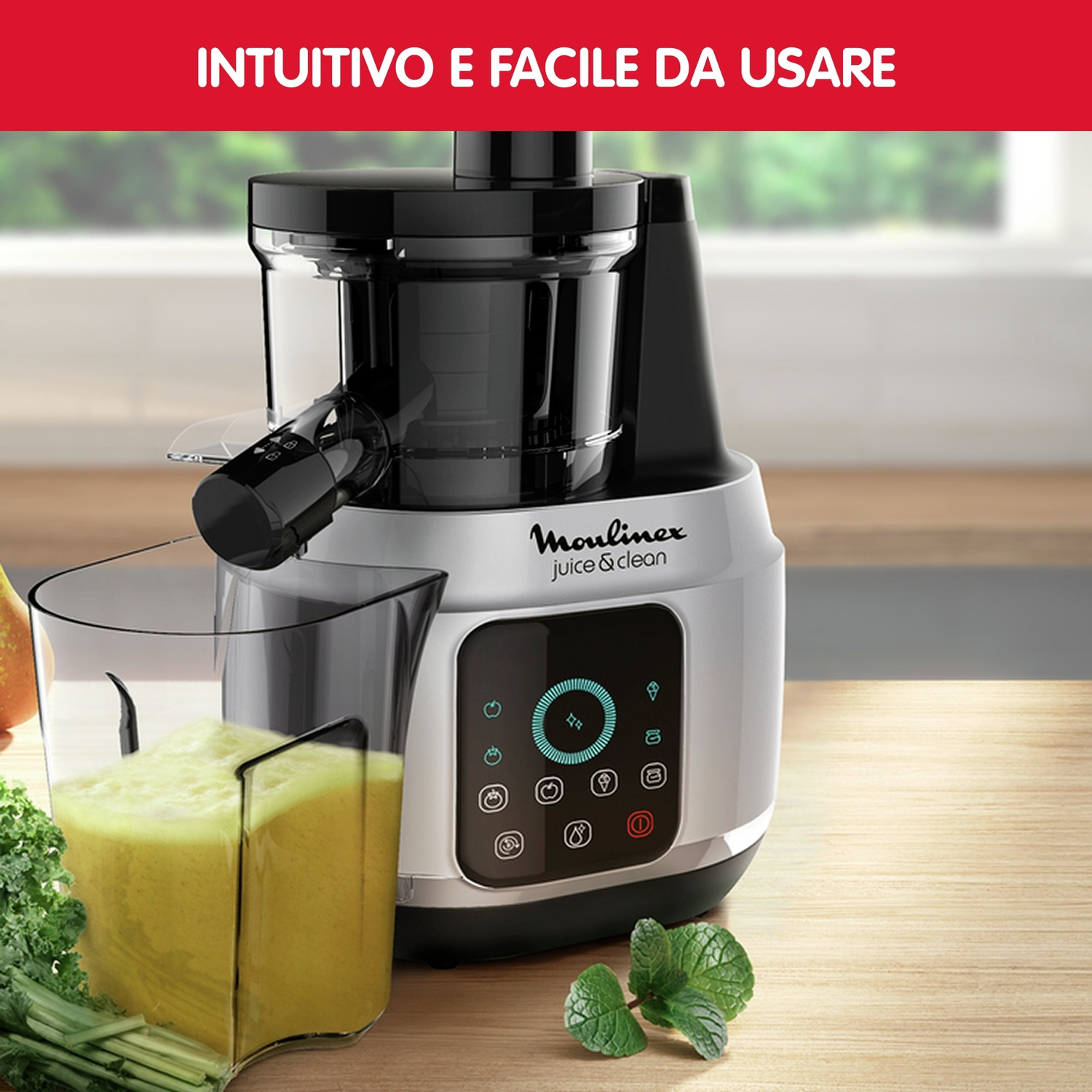 Un estrattore con un bicchiere di succo verde. Una superficie di legno e una finestra sullo sfondo.