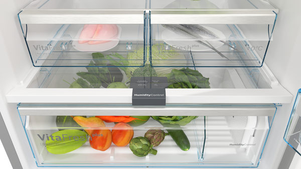 Taze ürünlerle dolu buzdolabı çekmeceleri: sebzeler, meyveler ve otlar. VitaFresh ve HumidityControl etiketli şeffaf kaplar.