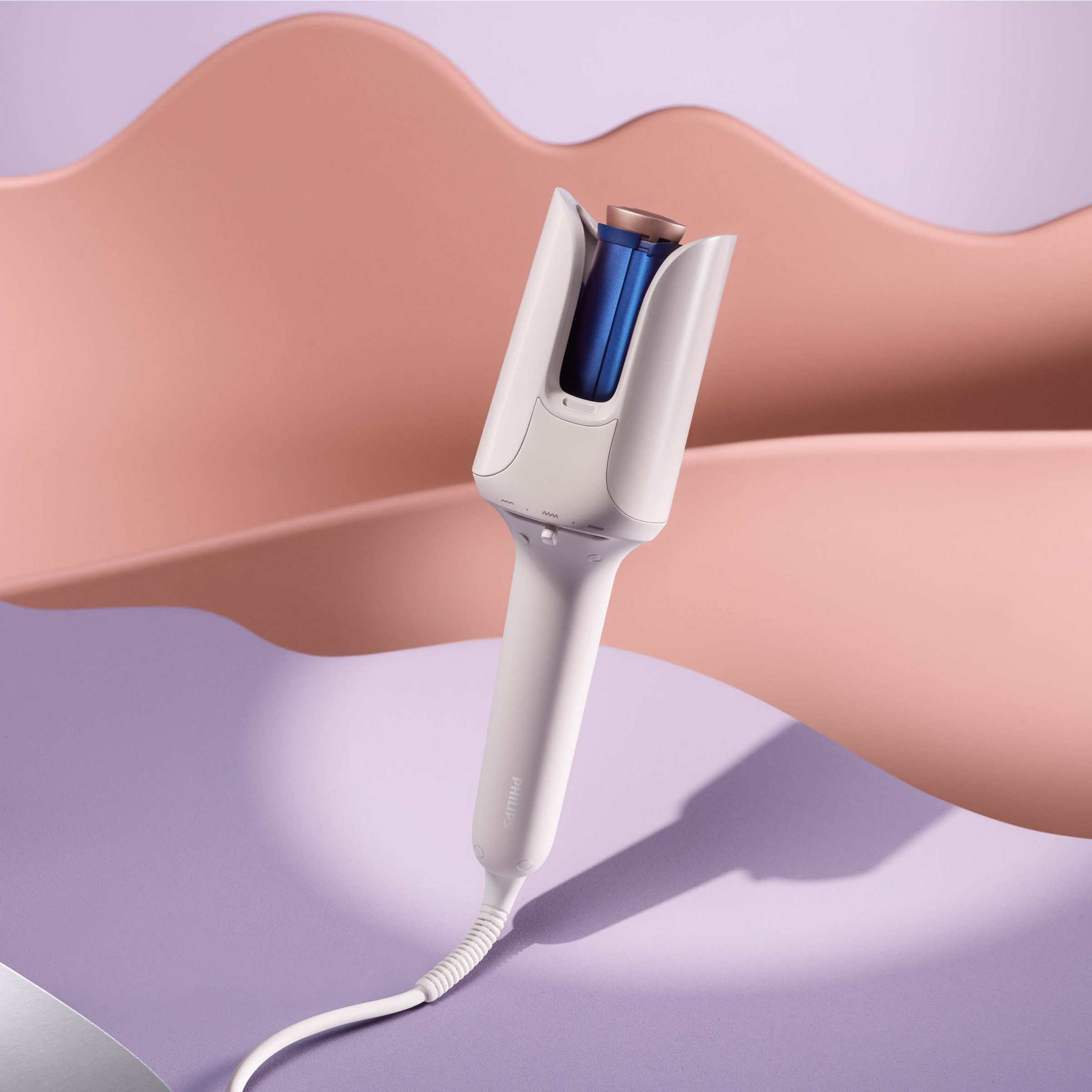 Biała lokówka na fioletowej powierzchni. Tło to różowy i brzoskwiniowy falisty kształt.