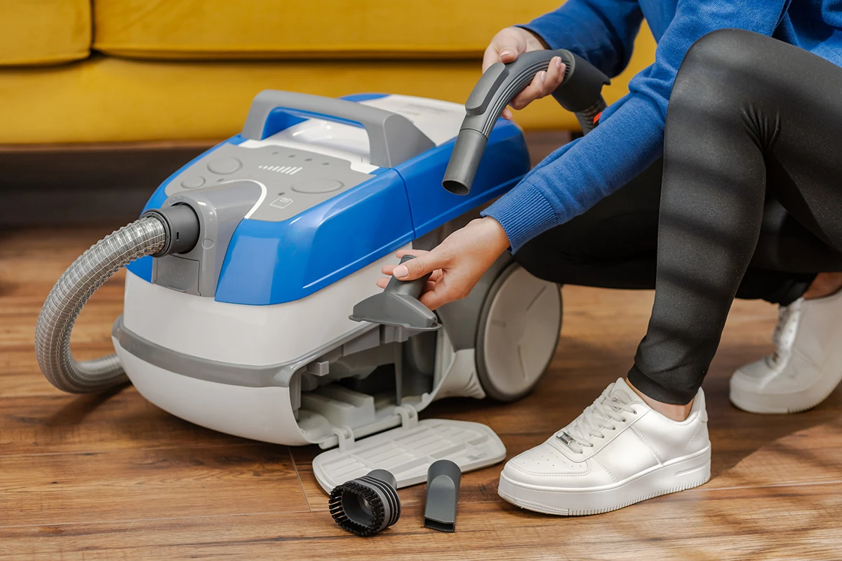 Osoba instaluje osprzęt odkurzacza.