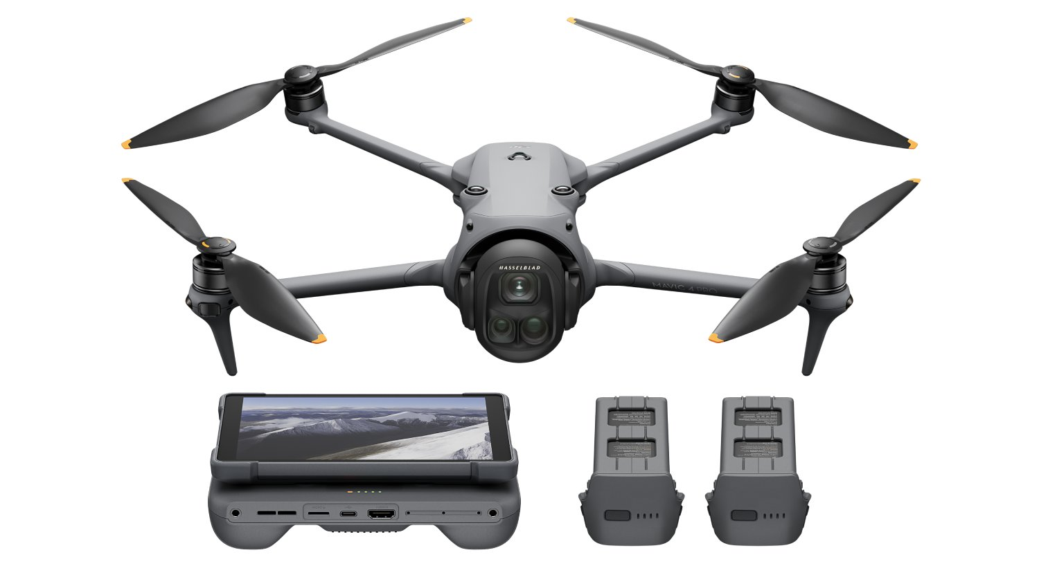 Dron, controlador y baterías. Dron centrado con hélices abiertas. Baterías a la derecha.
