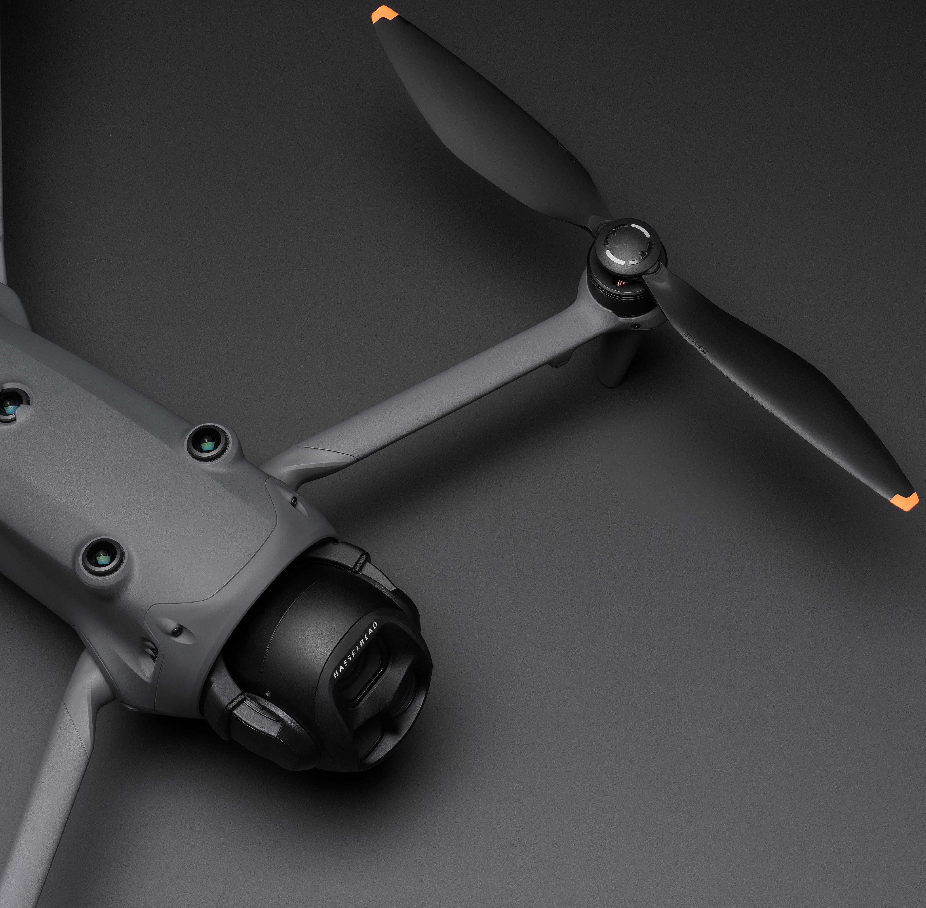 Drone e singola elica. Braccio del drone nero e grigio ed elica con punta arancione.