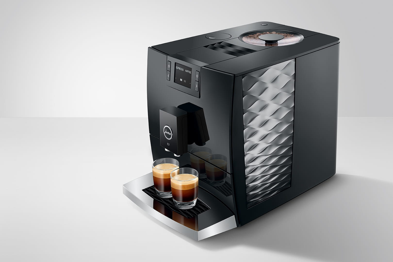 Macchina per espresso Jura nera. Due bicchieri di caffè sul vassoio. Il display mostra Espresso & Kaffee.