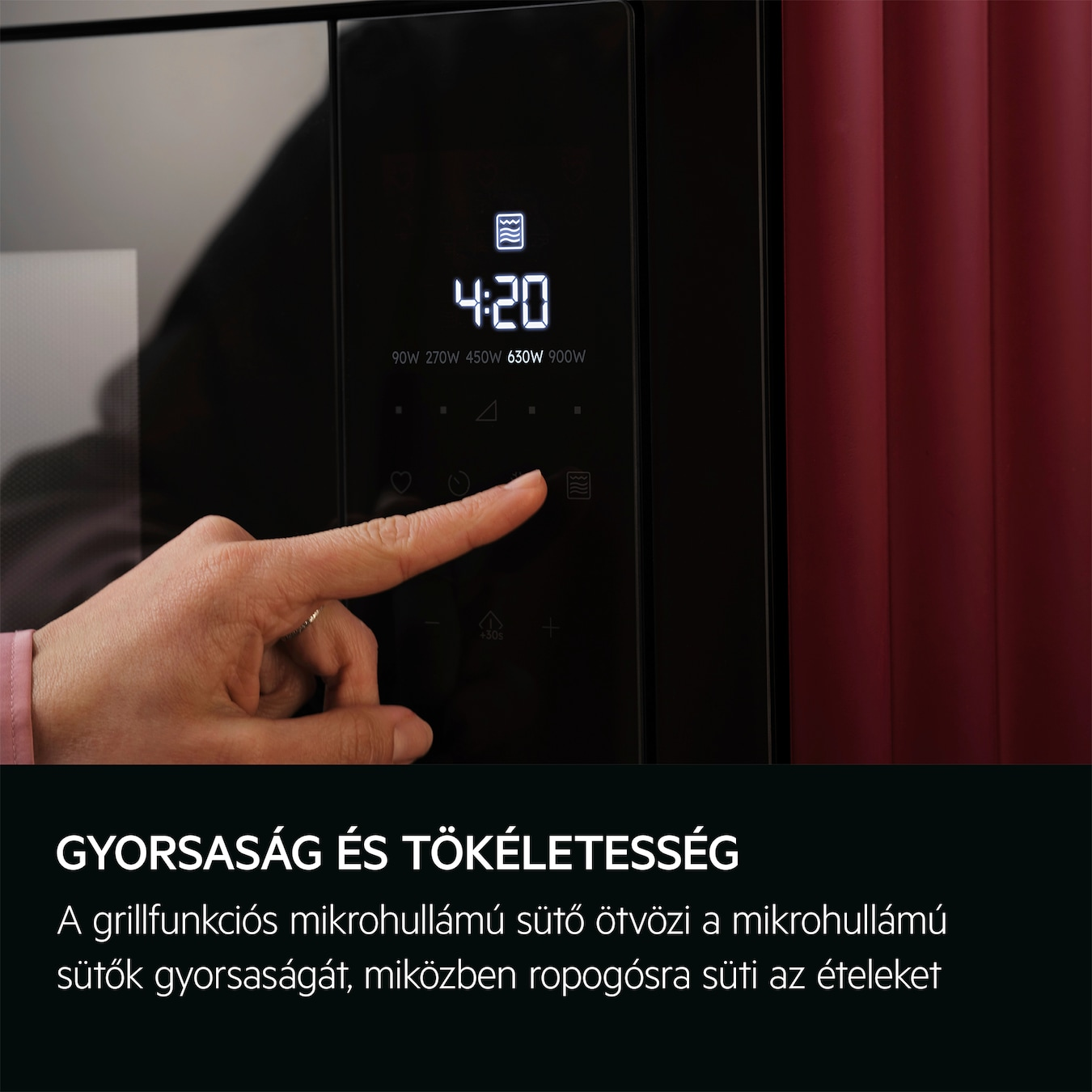 Egy személy keze egy tárcsát forgat a mikrohullámú sütő vezérlőpanelén, piros háttérrel.