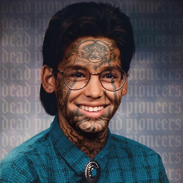 Ein Mann mit Tattoos und Brille auf dem Albumcover. Das Album ist Dead Pioneers. Er lächelt.