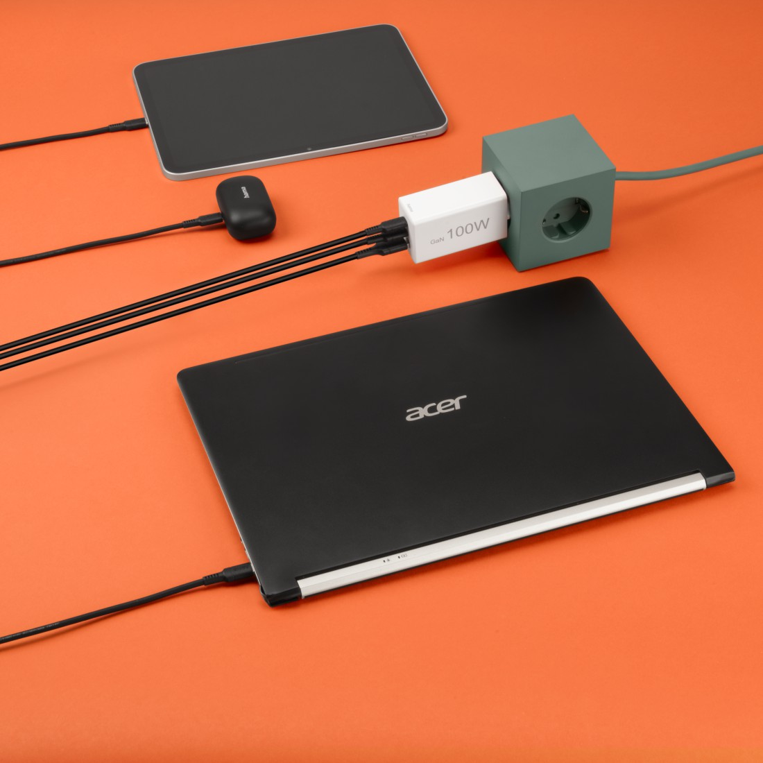 Geräte laden: Laptop, Tablet und Telefon, verbunden mit einem Ladegerät.