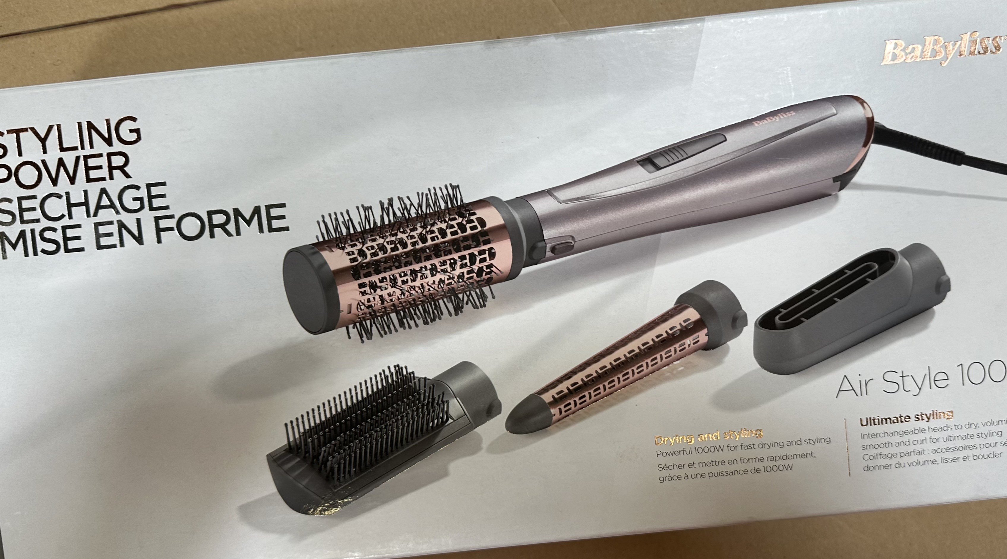 Zestaw do stylizacji włosów BaByliss Air Style 100 z wieloma nakładkami. Zestaw leży na białej powierzchni, z tekstem w tle.
