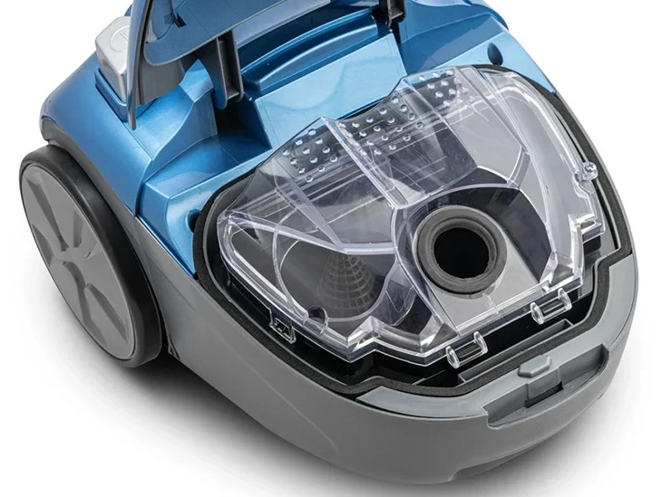 Odkurzacz w kolorze niebieskim i szarym z otwieraną pokrywą i przezroczystym pojemnikiem.