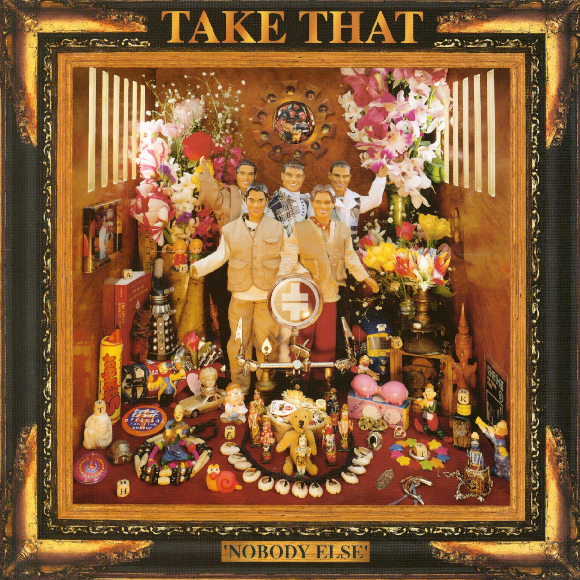 Albumcover, 'TAKE THAT' oben. Viele Figuren und Blumen in einer gerahmten Box.