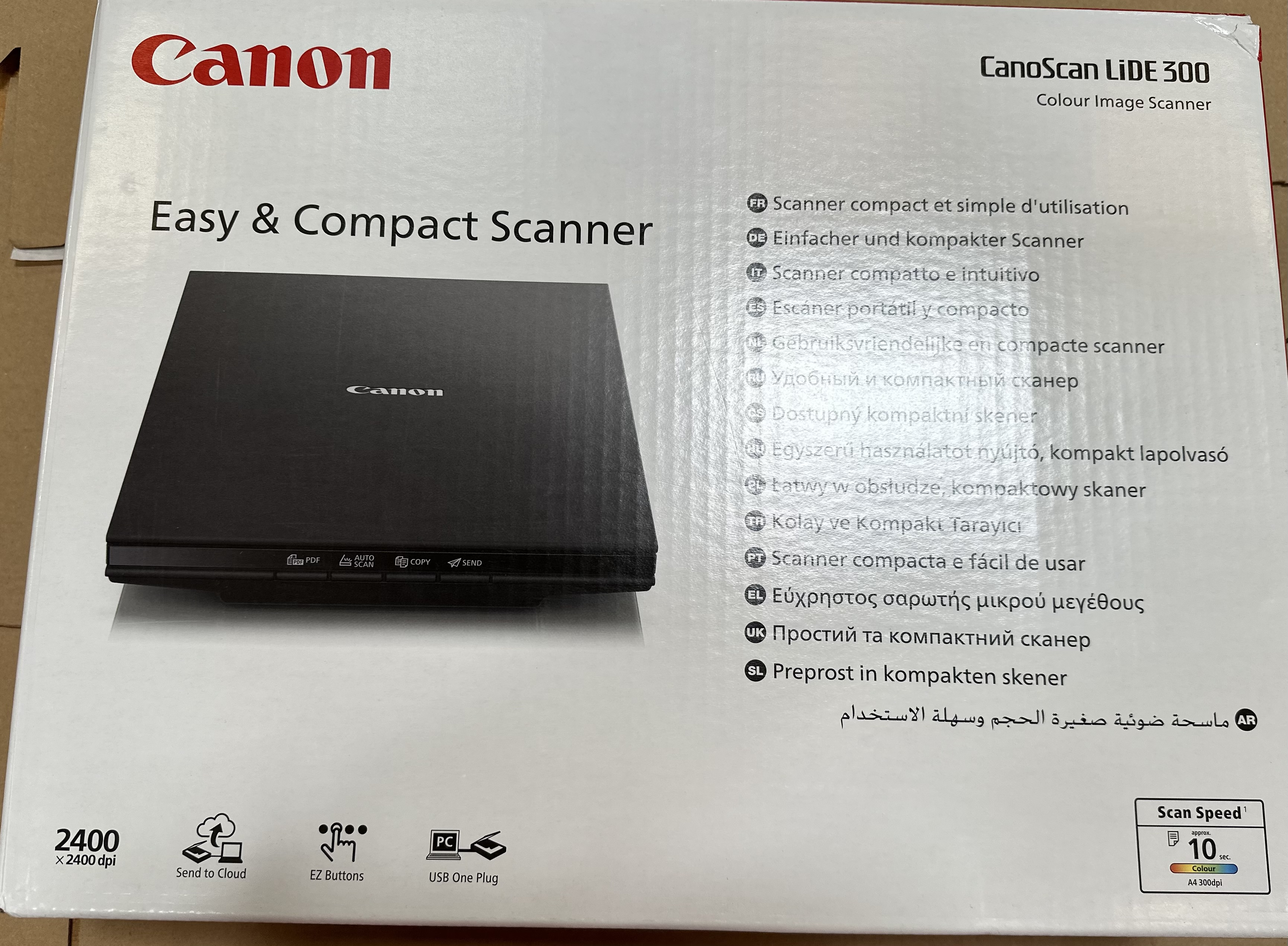 Pudełko skanera Canon. Pokazano czarny skaner. Tekst zawiera: Easy & Compact Scanner, CanoScan LiDE 300 i specyfikacje.