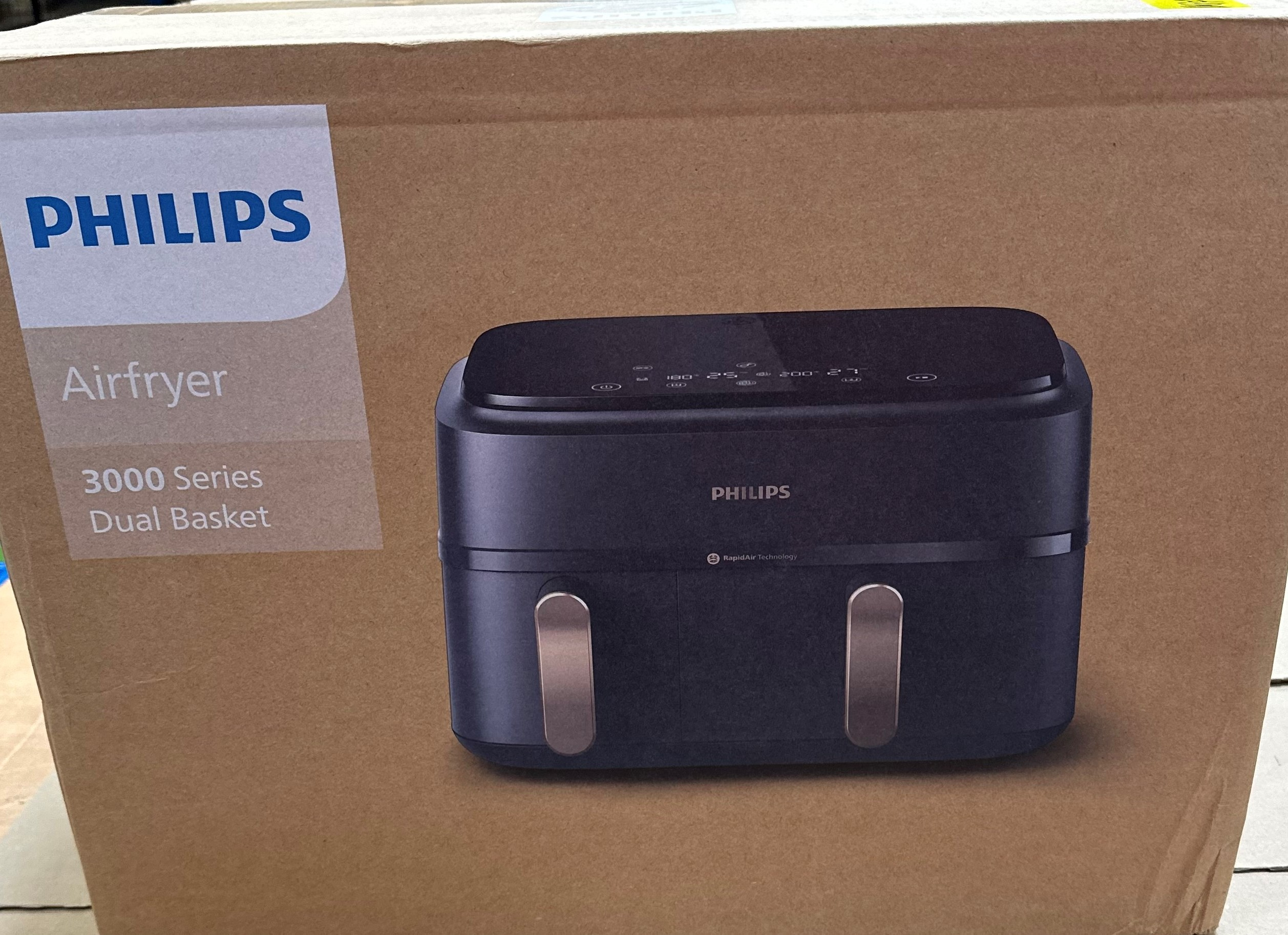 Zapakowana frytkownica Philips Airfryer, seria 3000, czarne urządzenie z brązowym tłem.