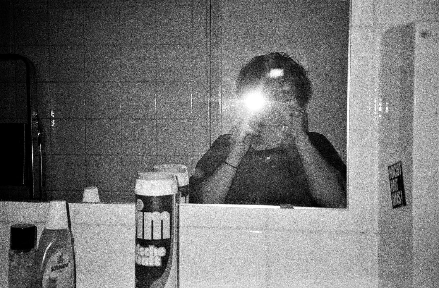Spiegelselfie, Badezimmer, Person hält Kamera.