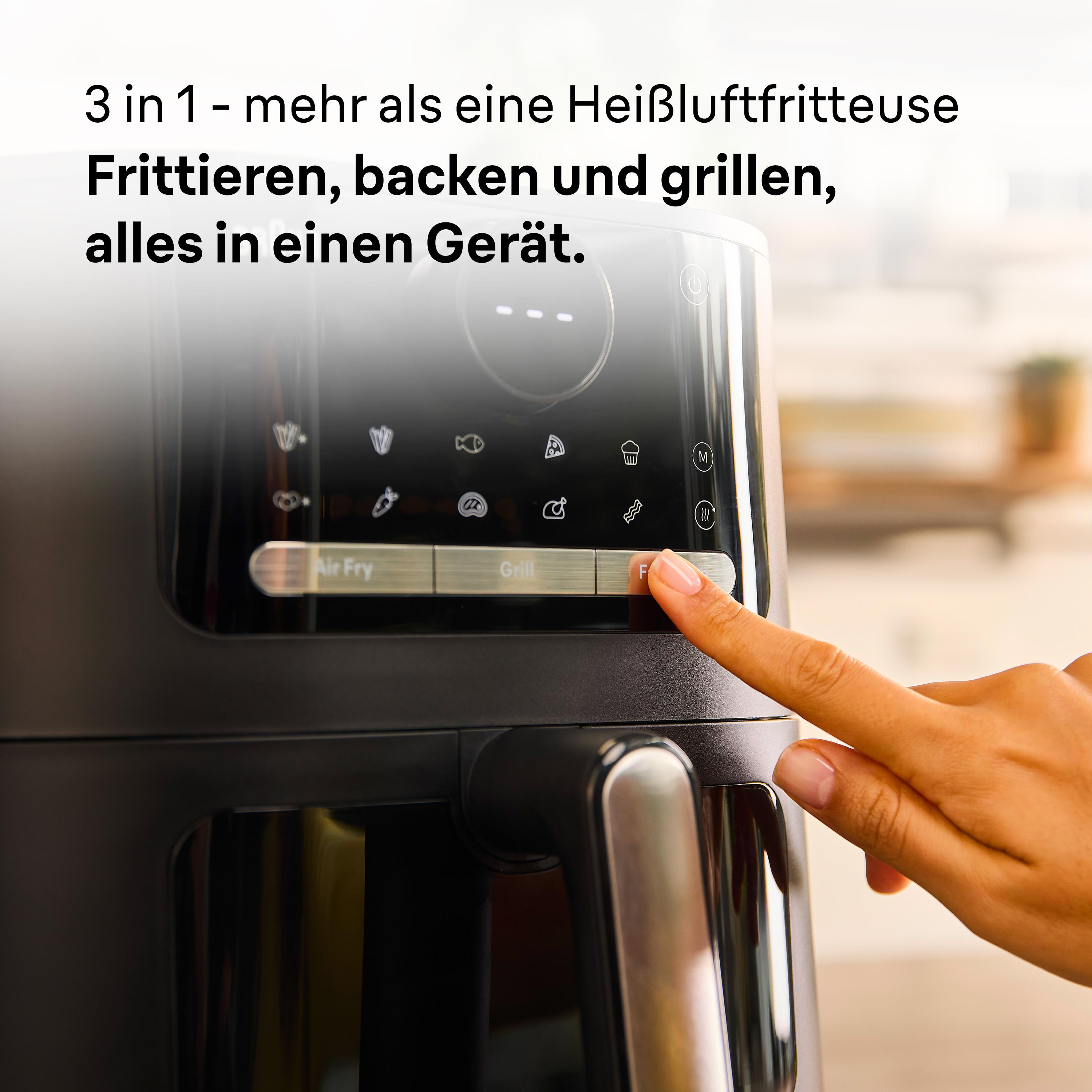 Der Finger einer Person, der auf eine Taste eines schwarzen Fritteuse drückt.