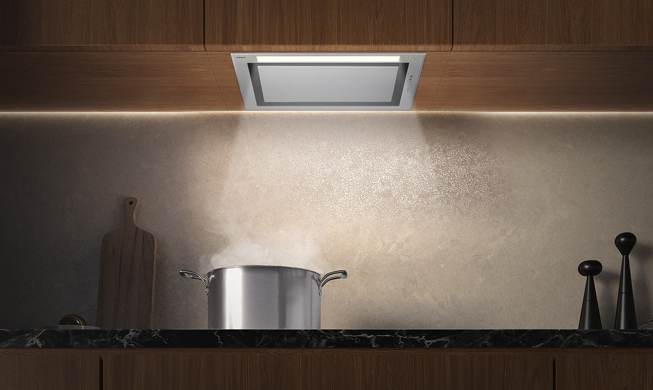 Okap kuchenny nad garnkiem z wrzącą wodą na kuchence.