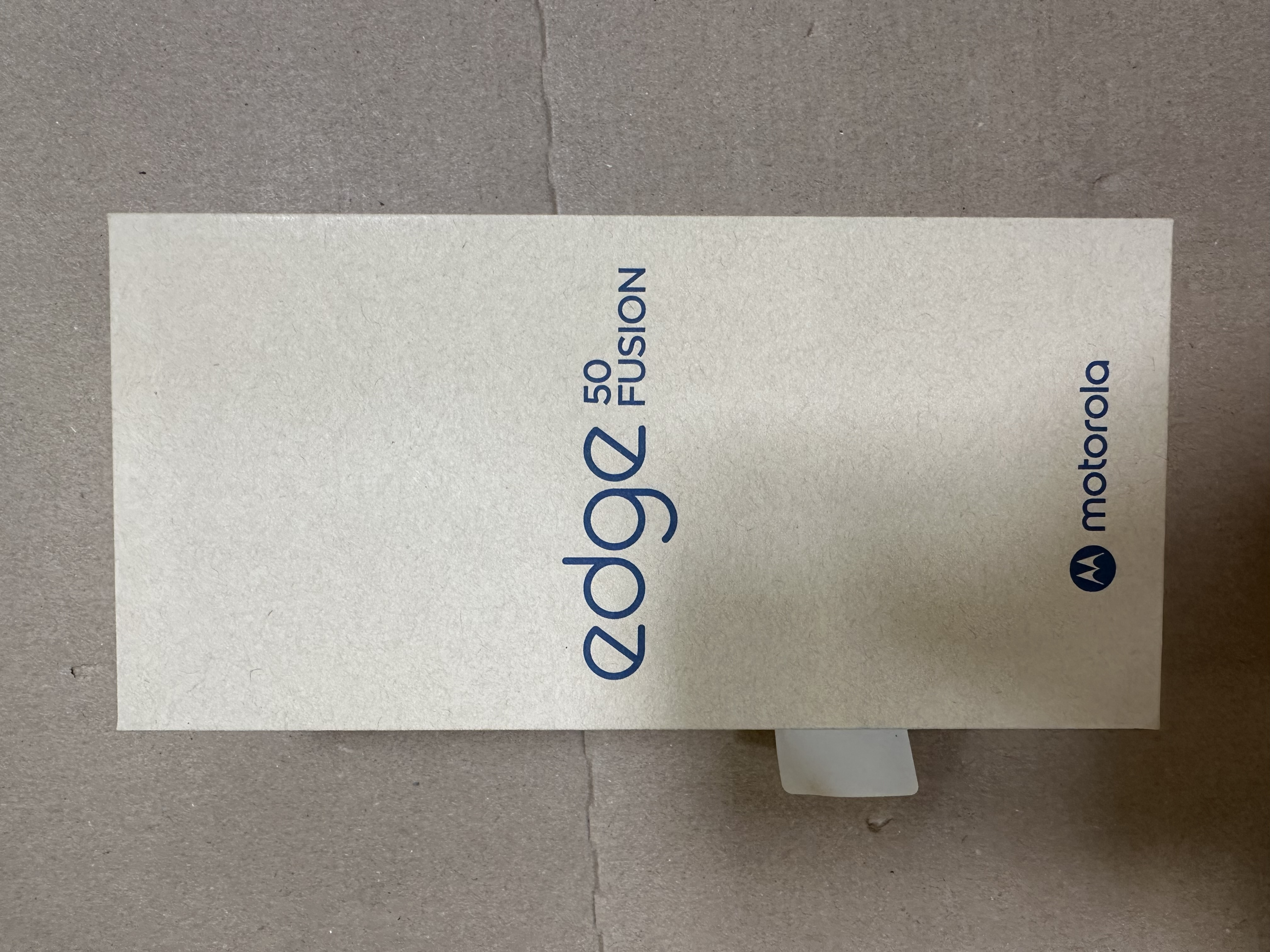 Pudełko od telefonu, tekst 'edge 50 fusion' i logo motorola, wszystko w kolorze białym.