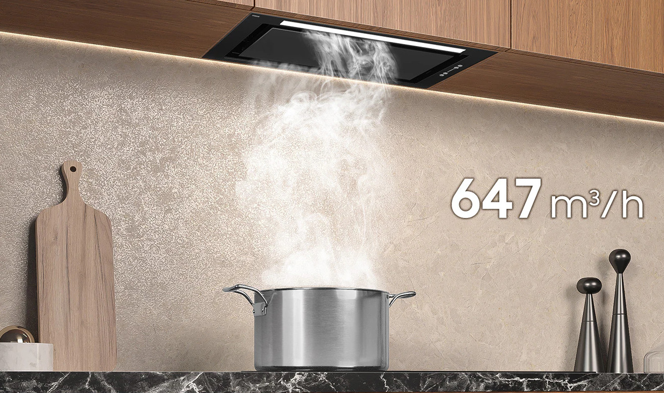 Dym z garnka jest zasysany przez czarny okap. Wyświetlane jest 647 m3/h.