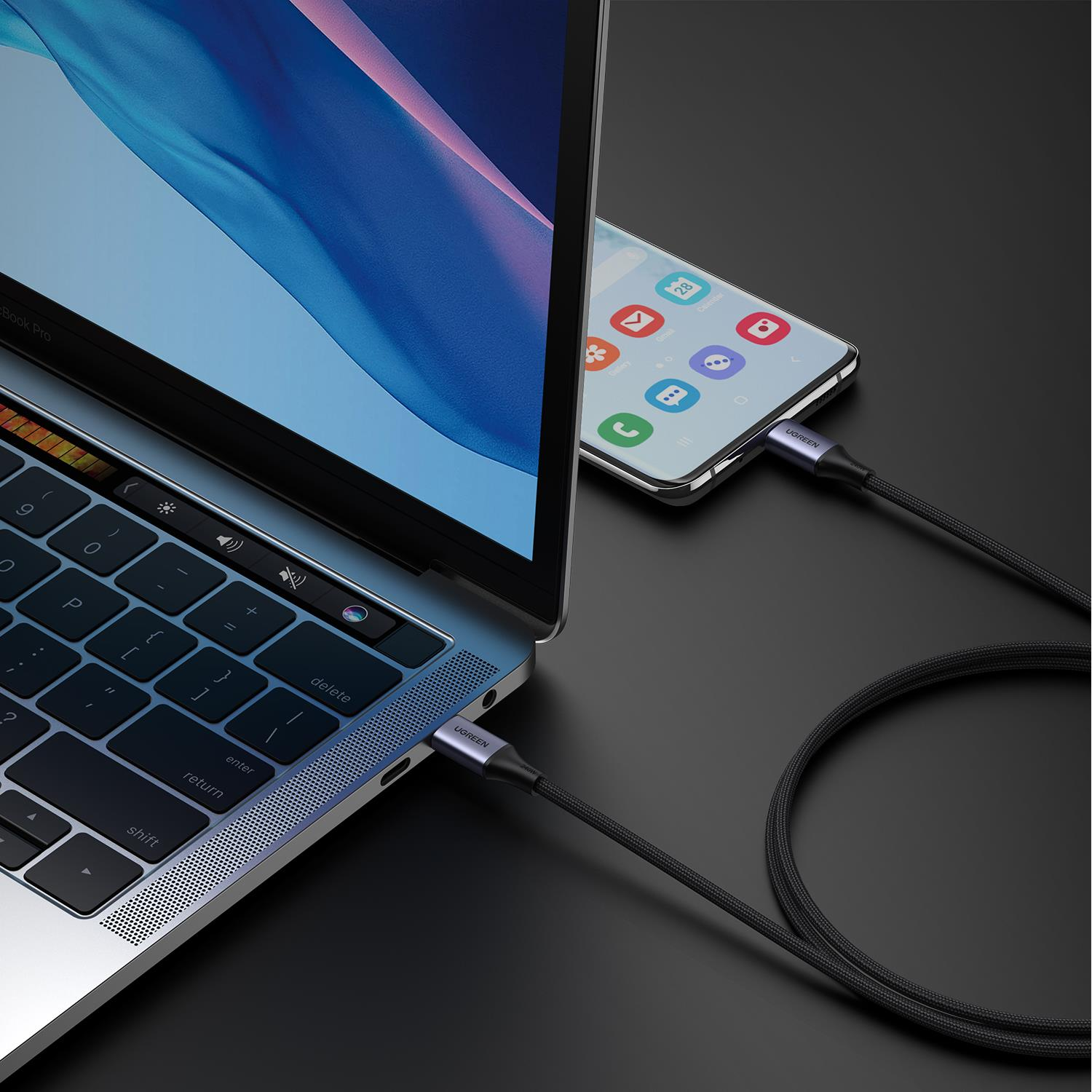 Dizüstü bilgisayar ve telefon USB-C kablosuyla şarj oluyor. UGREEN kablosu her iki cihazı bağlar.