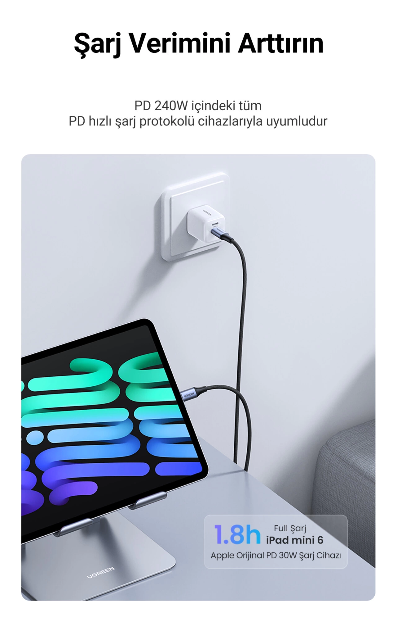 Siyah bir USB-C kablosu aracılığıyla bir priz ile bağlanan bir iPad mini. Bir duvar prizi ve bir masa görülebilir.