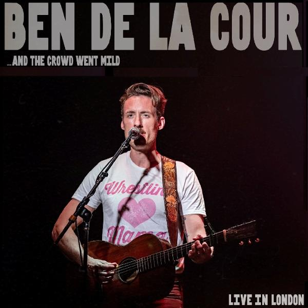 Albumcover: Mann mit Gitarre singt, trägt ein T-Shirt und steht auf der Bühne.