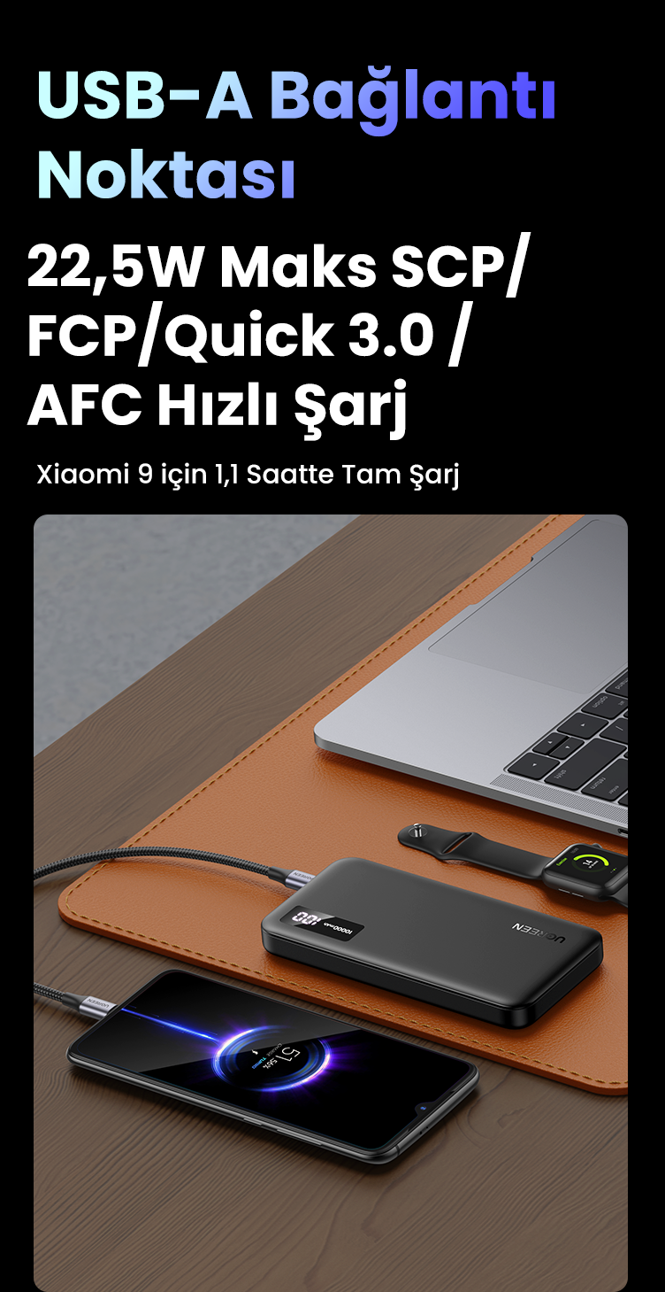Bir masada powerbank ile şarj olan telefon. Ayrıca bir dizüstü bilgisayar ve saat var.