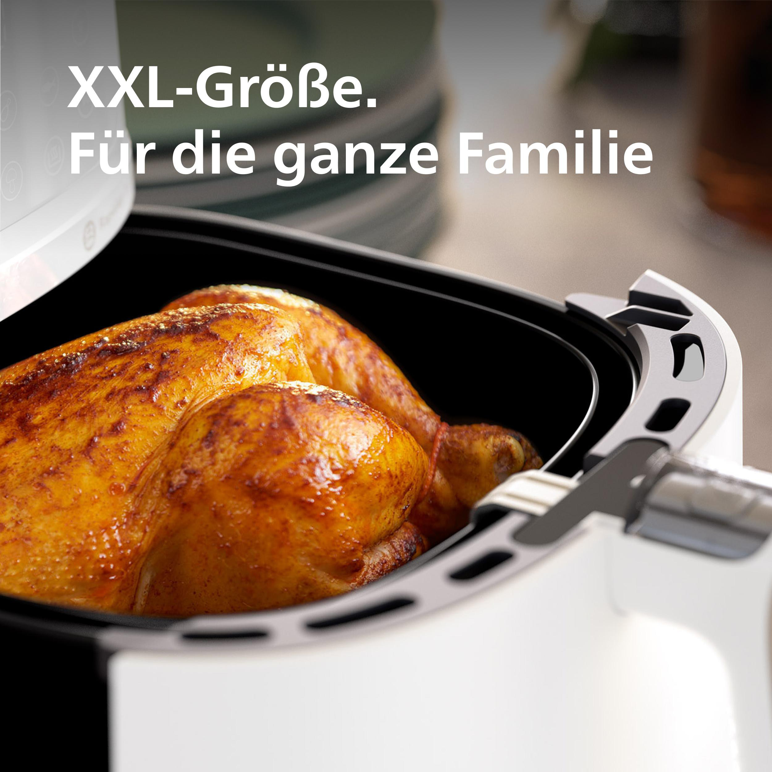 Weißer Heißluftfritteuse, Nahaufnahme von gebratenem Hähnchen im Inneren. Weißer Hintergrund.