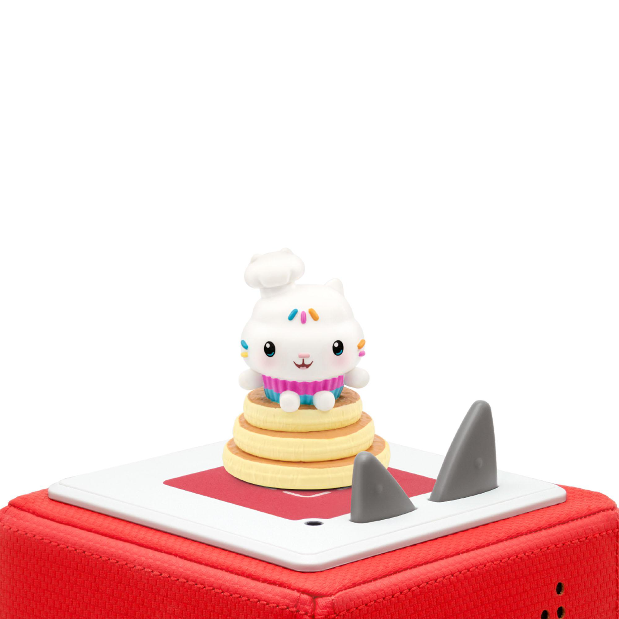 Eine Cupcake-Katzenfigur auf Pfannkuchen, oben auf einem roten Würfel mit Haifischflossen.
