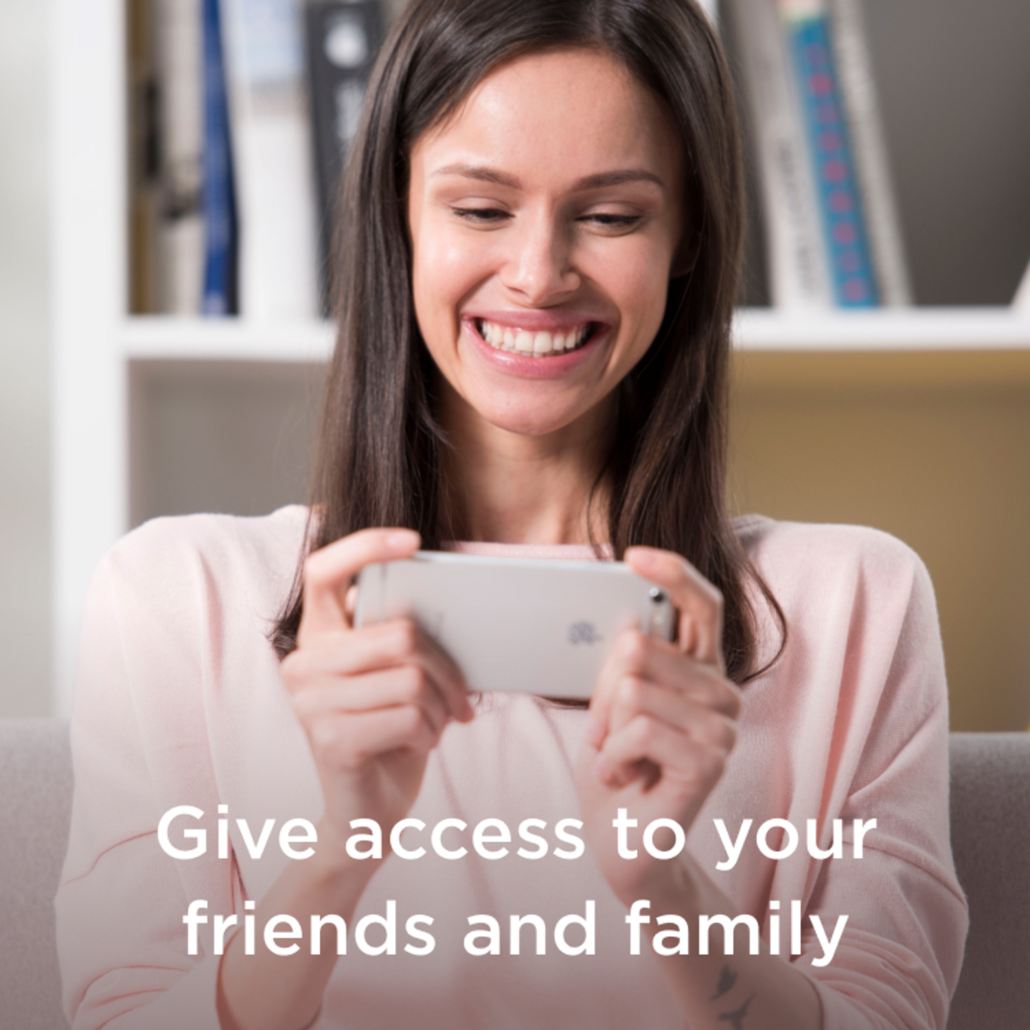 A smiling woman is looking at a phone. Text: Give access to your friends and family.
