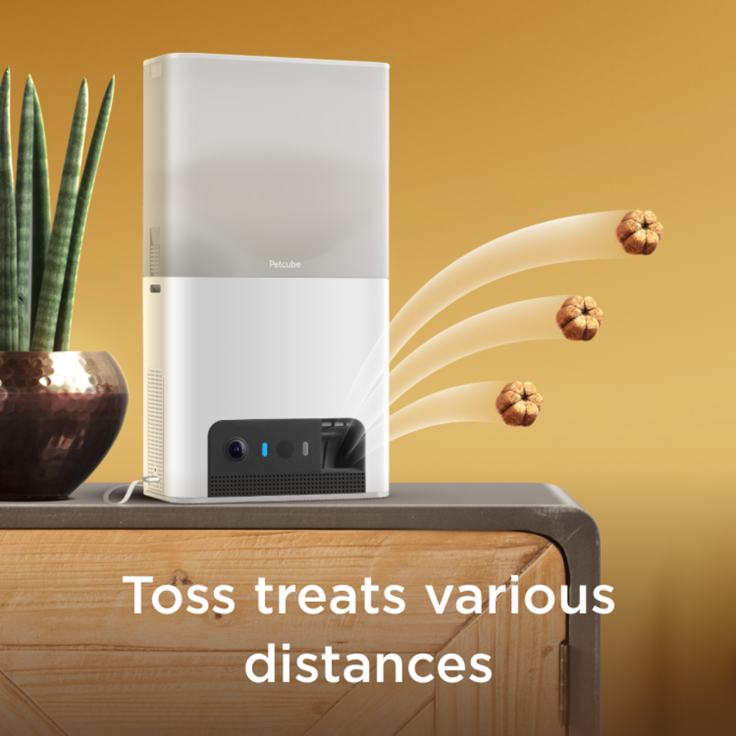 Petcube device tossing treats. Treats in the air. Text: Toss treats various distances.