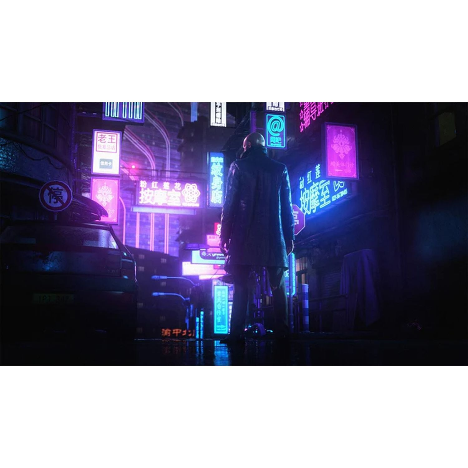 Een man staat 's nachts in een met neon verlichte straat. Borden in een vreemde taal.