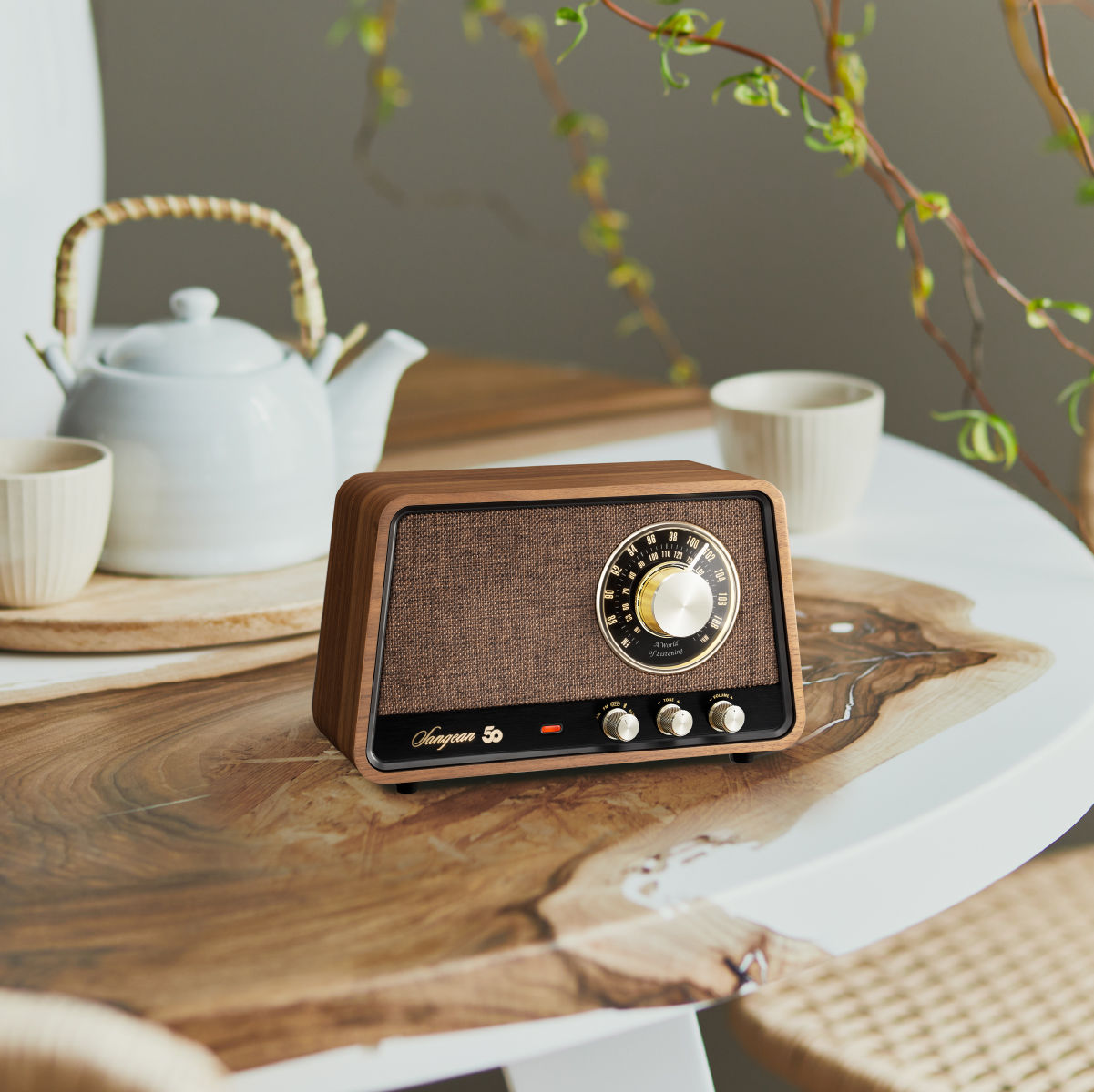 Holzradio auf einem Tisch mit anderen Gegenständen. Dunkles Holz und brauner Lautsprecher. Schwarzer Hintergrund.