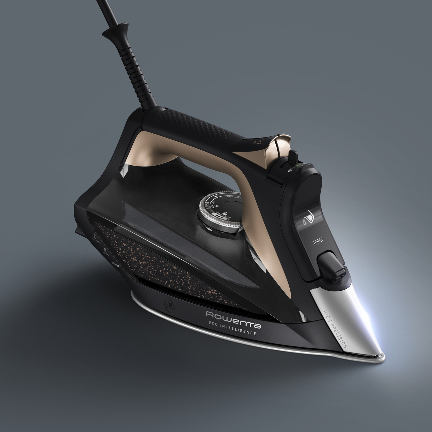 A black and gold iron, with a control dial, resting on a gray surface against a gray background.