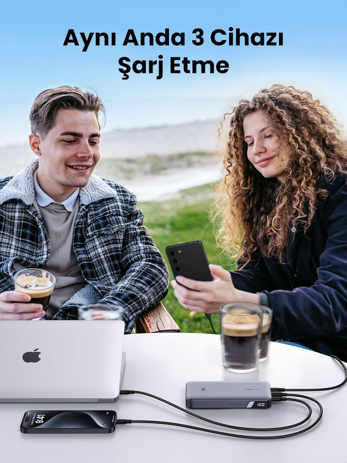 İnsanlar, kahve içerken açık havada çoklu cihazları şarj etmek için bir powerbank kullanıyor.